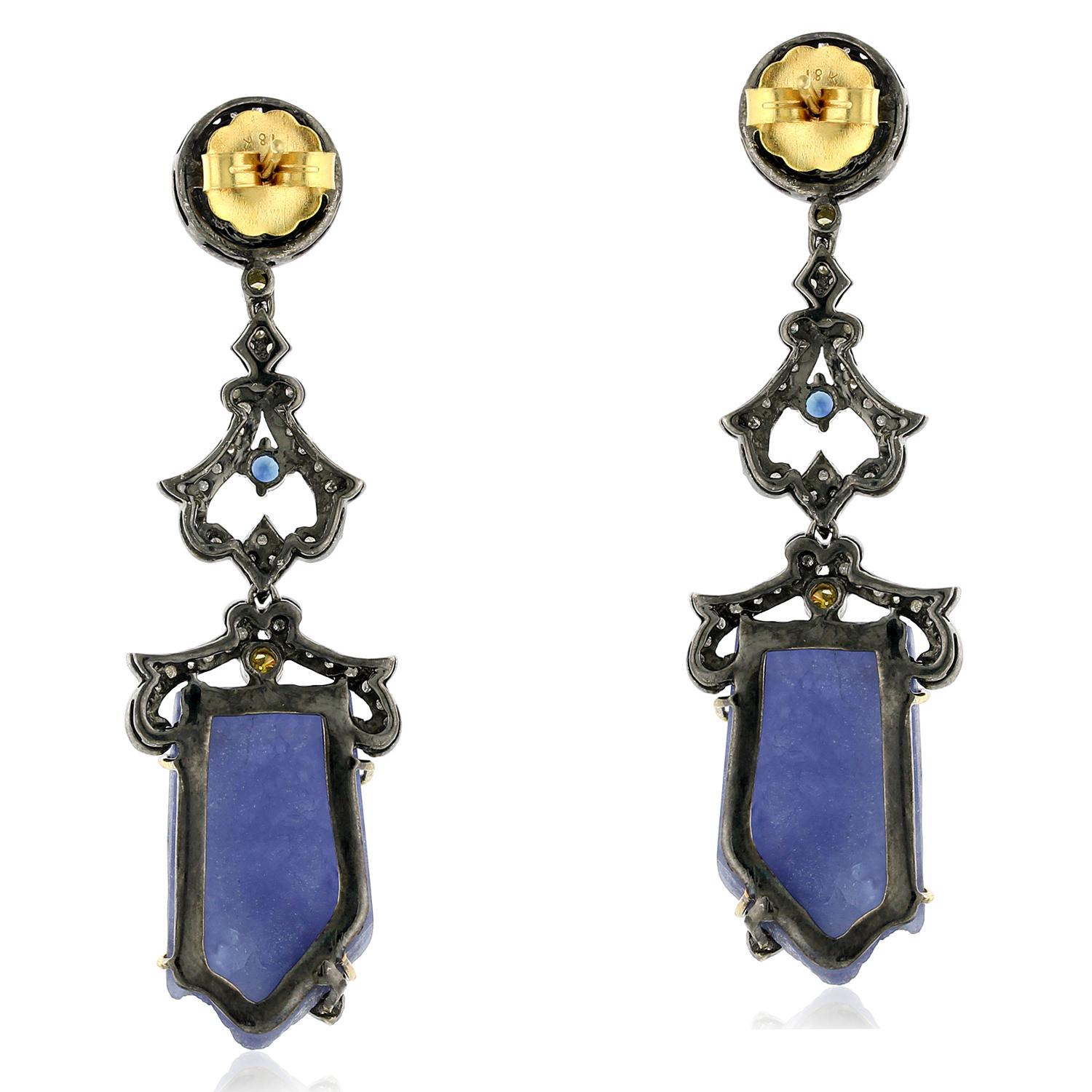 These stunning tanzanite dangle earrings are a true work of art. Handcrafted with the finest materials, these earrings feature a pair of sparkling tanzanite gemstones and shimmering sapphires. The earrings are finished with 18k gold and silver,