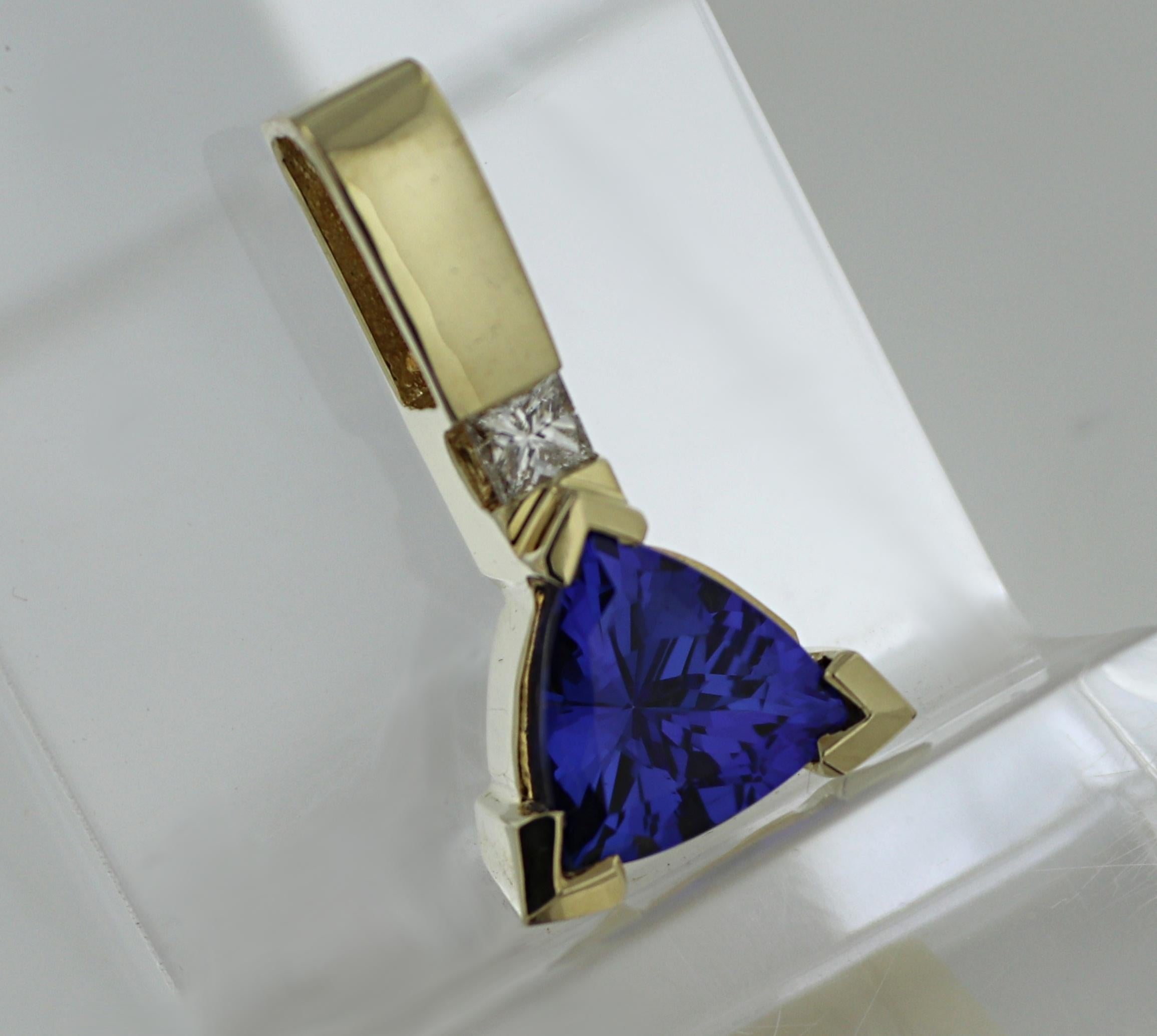 Featuring (1) triangular-cut beautifully saturated purple tanzanite, 3.45 cts., surmounted by (1) princess-cut diamond, 0.15 ct., VS, I-J, set in a 14k yellow gold mounting, 24.3 X 13.3 X 7.3 mm, Gross weight 5.43 grams.