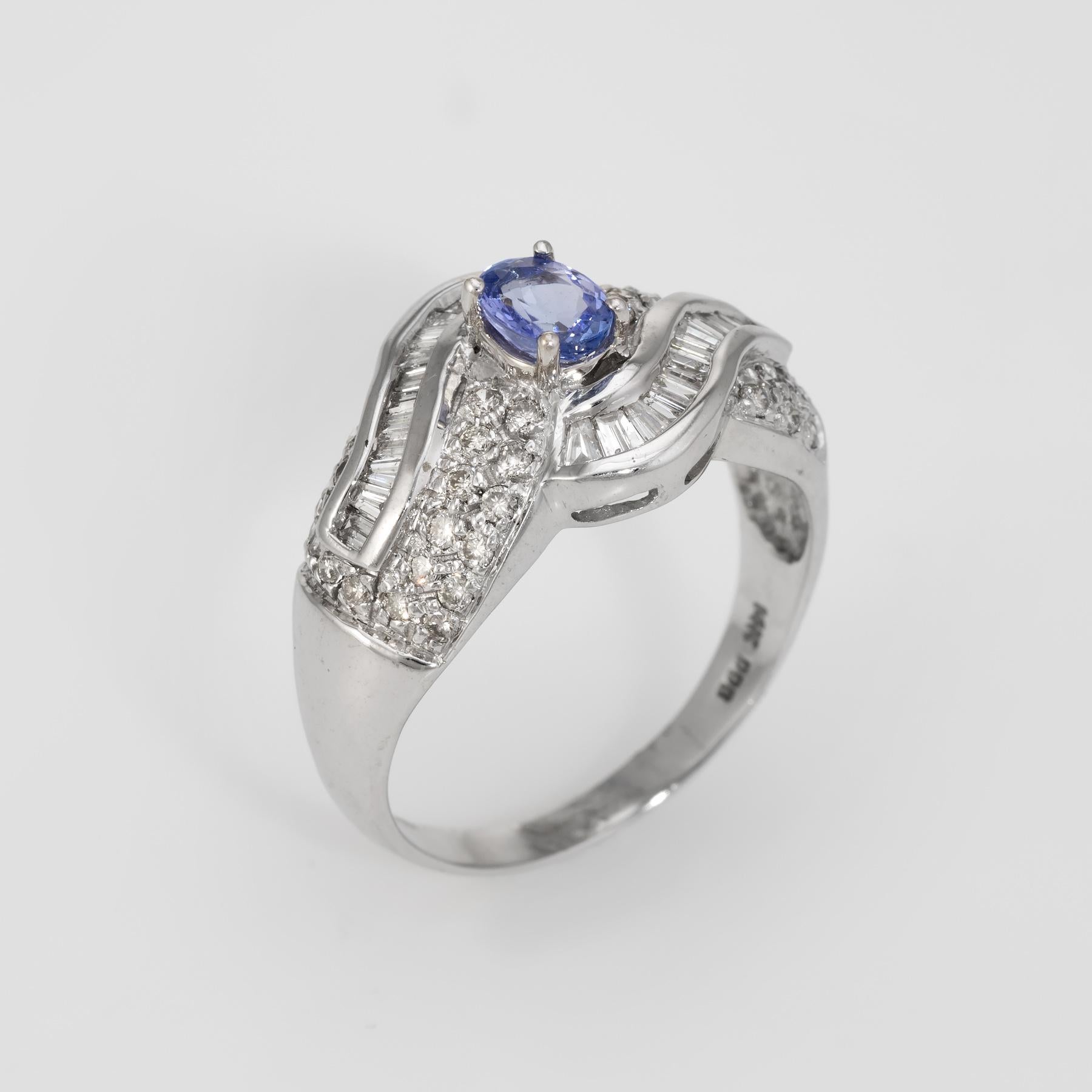 Finely detailed estate cocktail ring, crafted in 14 karat white gold. 

Centrally mounted faceted oval cut tanzanite measures 6mm x 4mm (estimated at 0.50 carats), accented with baguette and round brilliant cut diamonds that total an estimated 0.94