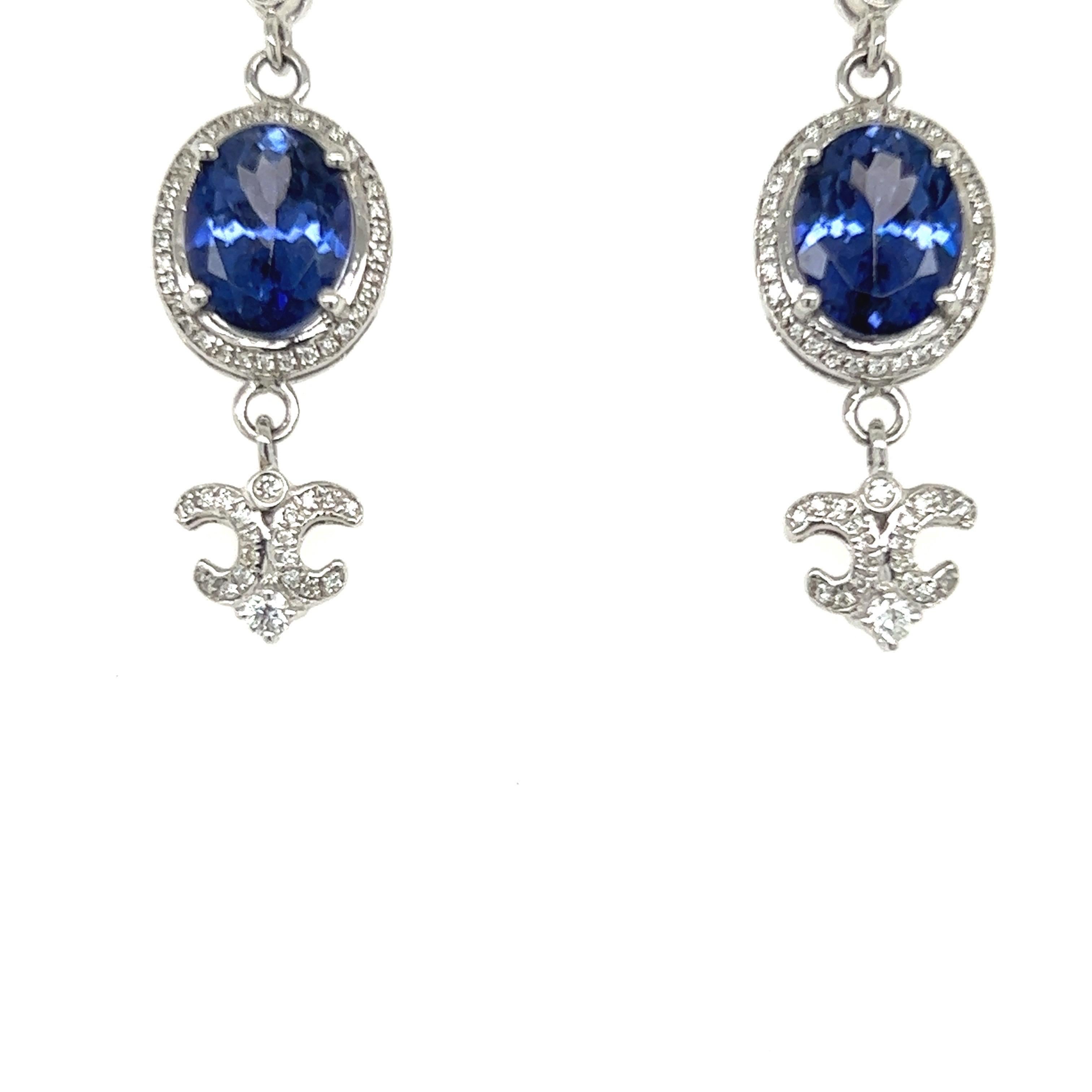 Stunning Tanzanite dangling earrings. High brilliance, purplish blue, oval faceted natural 4.08 carats tanzanite mounted in high profile with four bead prongs. Accented with round brilliant cut diamonds. Handcrafted design is set in 14 karat white