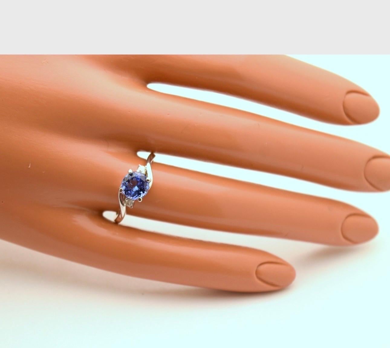 Three stone ring in platinum featuring single 6mm tanzanite and 2 small 2mm diamonds. The tanzanite is a deep violet color and diamonds are VS clarity and F color. Ring comes with a box and appraisal.

Certificate of authenticity comes with