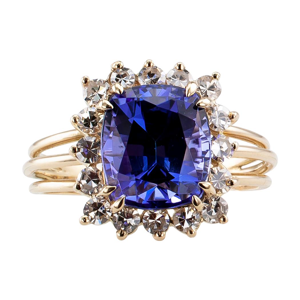 Tanzanite and diamond estate gold ring. Centering upon a cushion-shaped tanzanite weighing approximately 3.30 carats, within a conforming border set with sixteen single-cut diamonds totaling approximately 0.50 carat, approximately H color and VS