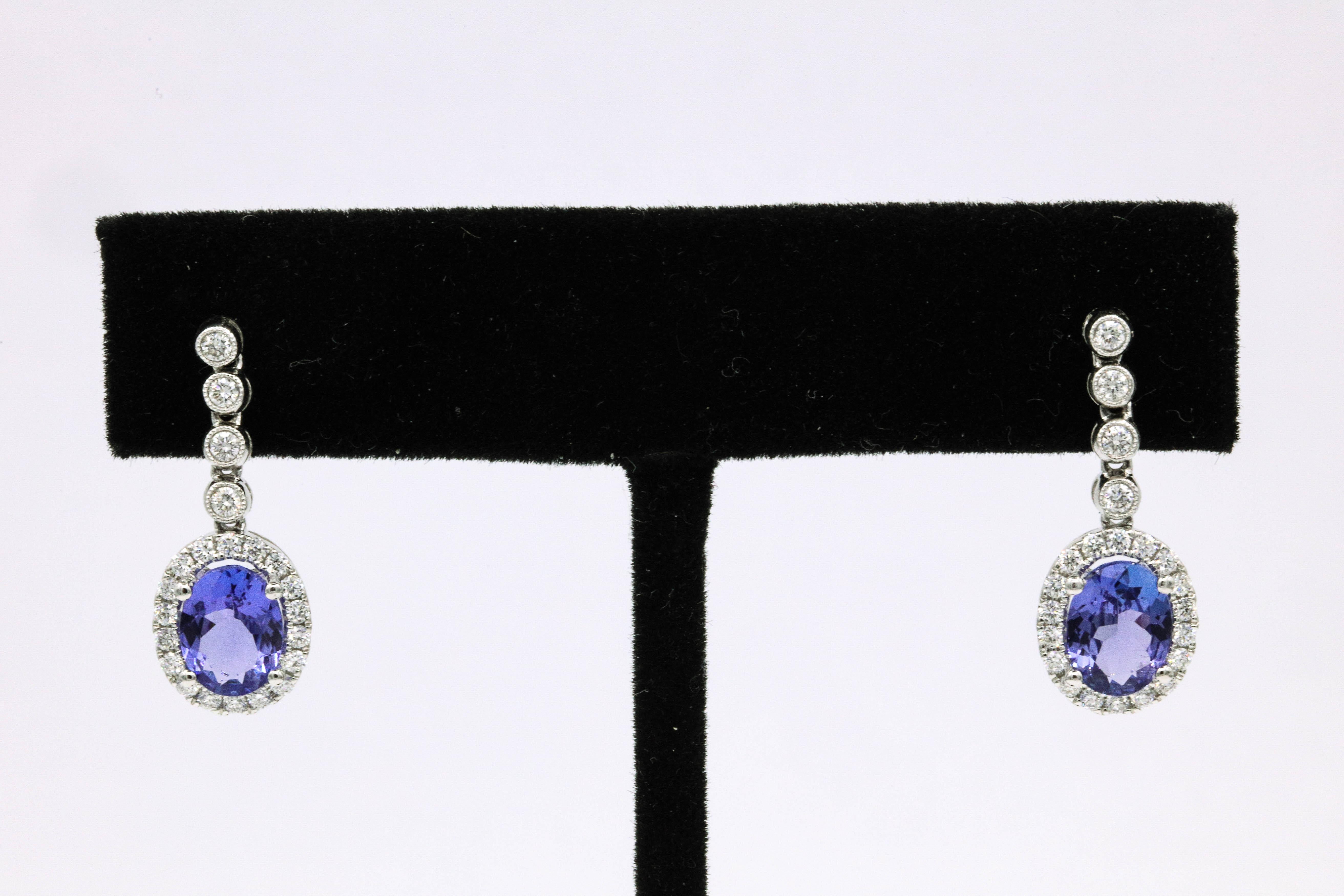 18k White Gold drop earrings featuring two oval shape tanzanites, 2.60 carats surrounded by round brilliants weighing 0.55 carats.
Color G-H
Clarity SI