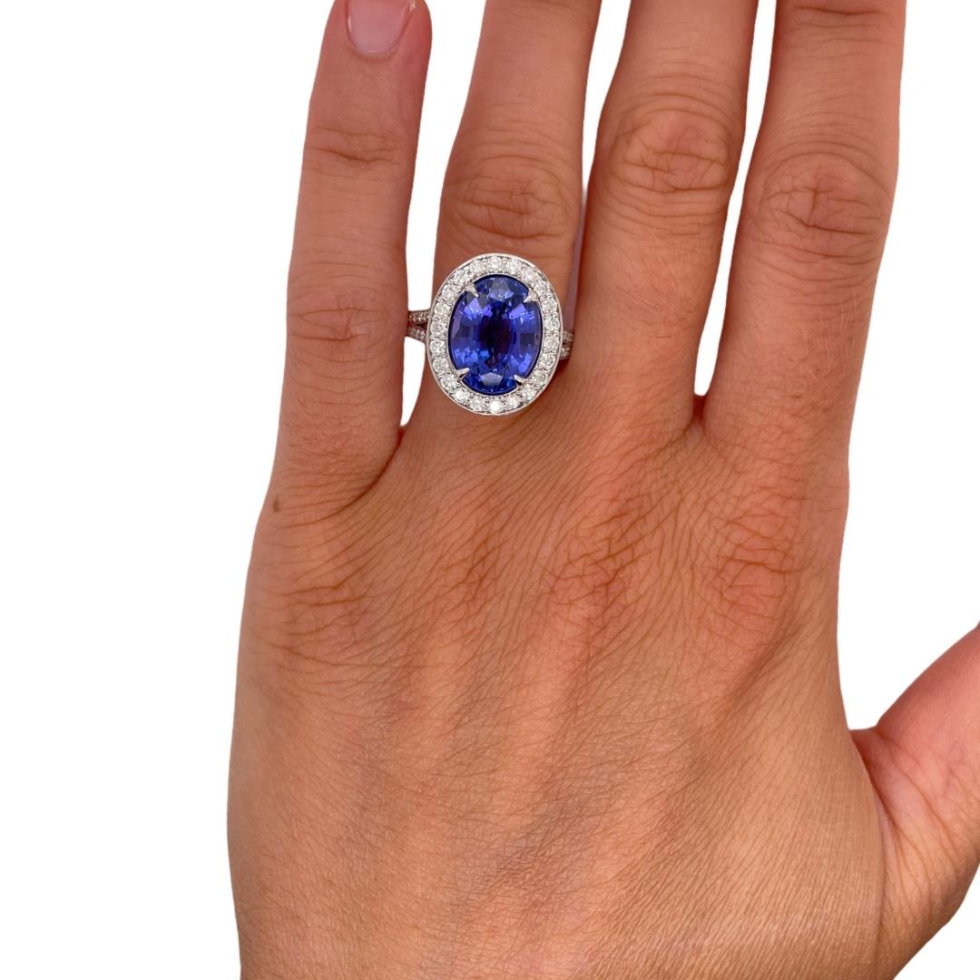 Ring contains 1 fine oval tanzanite weighing 6.00cts. Center stone is surrounded by round brilliant diamonds creating a halo accent with a double split band. Diamonds weigh 1.10tcw and are near colorless, SI1 in clarity, excellent cut. All stones