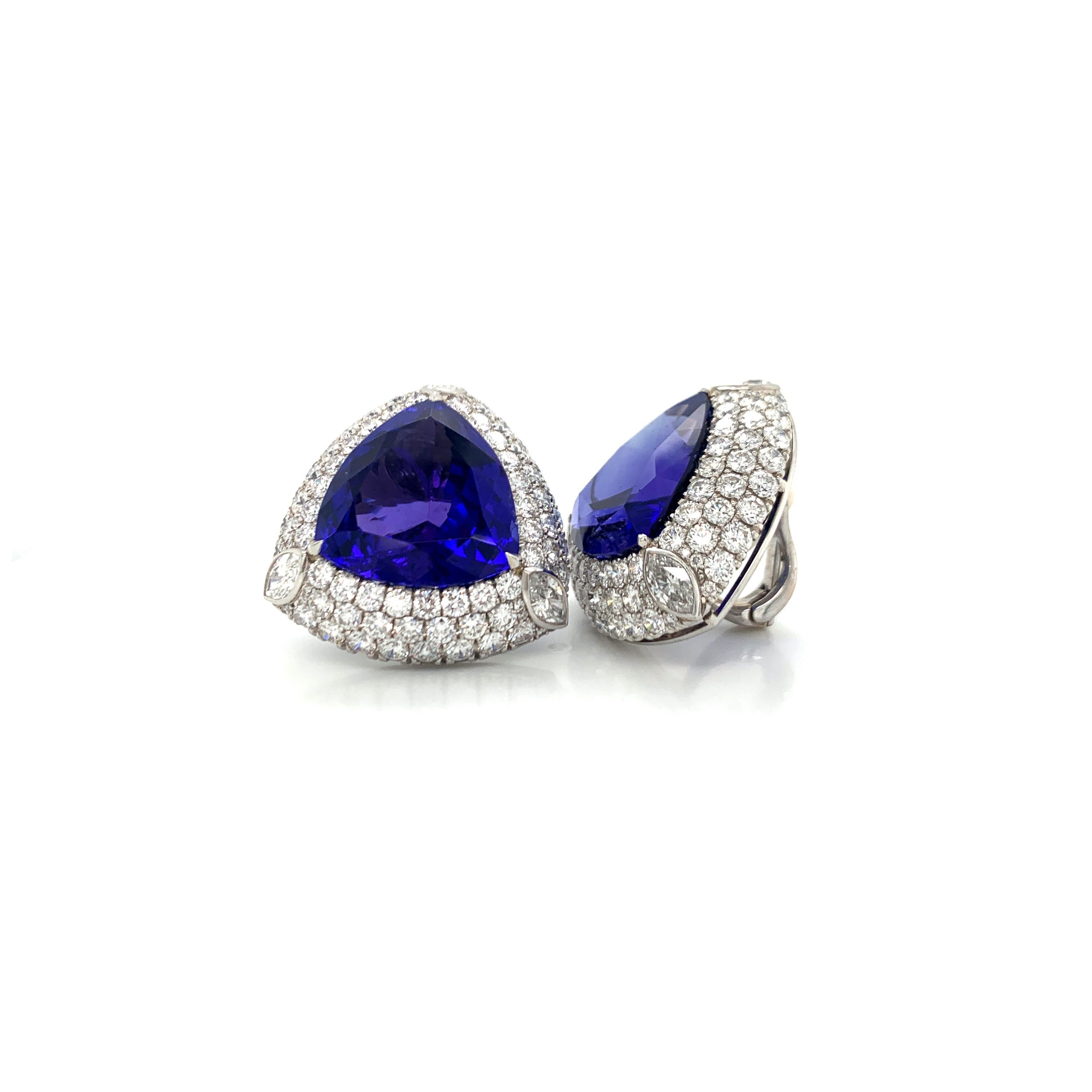 The custom cut, deep blue tanzanites are elegantly framed with round and marquise diamonds.  The design is a powerful burst of blue in contrast to the bright white diamonds.  The earrings are well proportioned to sit perfectly, and comfortably, on