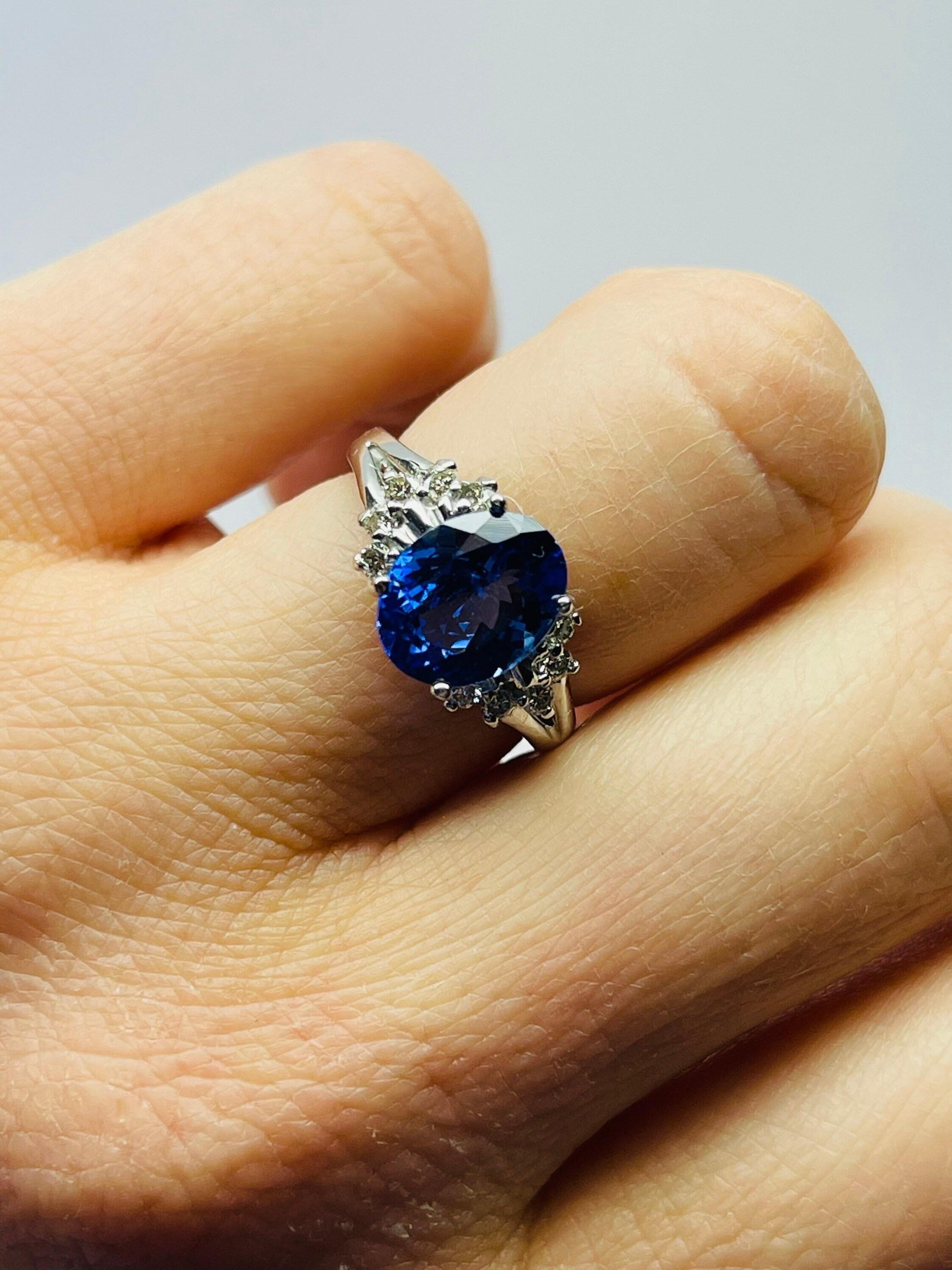 Stunning large tanzanite deep purple color oval shape accompanied by small diamonds on the band and compliment the ring so well. The tanzanite has a nice luster and depth you can see the color is medium purple and looks absolutely beautiful. The