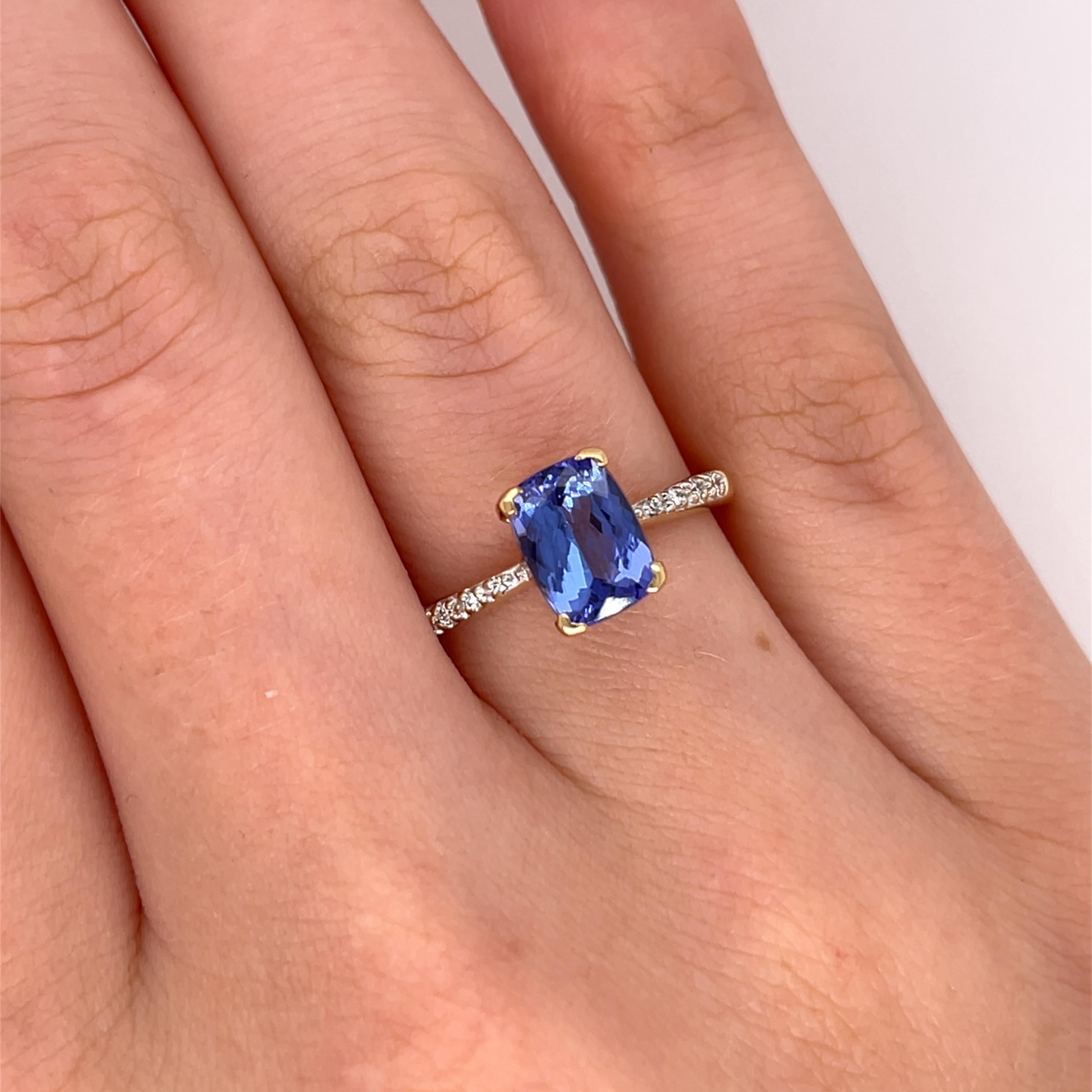 Cette superbe bague est ornée d'une vibrante tanzanite, magnifiquement complétée par des diamants étincelants, le tout serti dans un luxueux or jaune 18ct. Le bleu captivant de la tanzanite, associé à l'éclat des diamants, fait de cette bague une