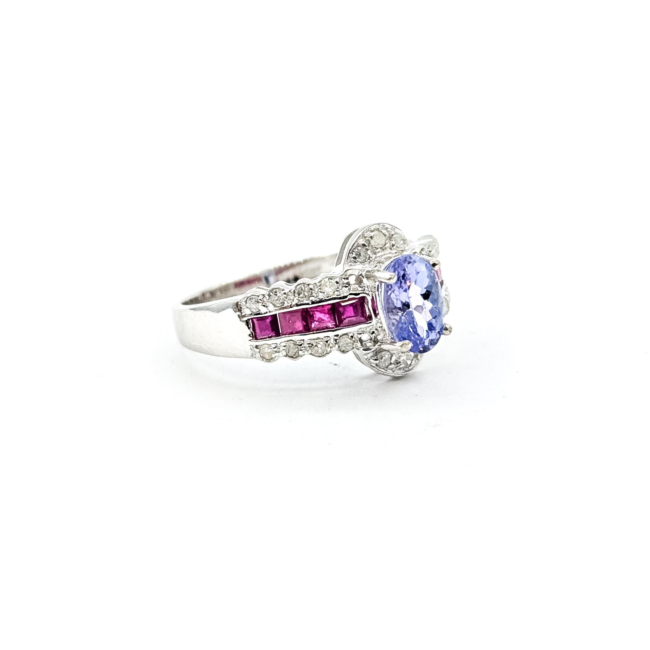 Tanzanite, Diamond 
Ruby Ring in 14k white gold

This ring is crafted in 14k white gold and features a pastel violet oval tanzanite secured in a four-prong setting. The center stone is framed by diamond accents above and below, while