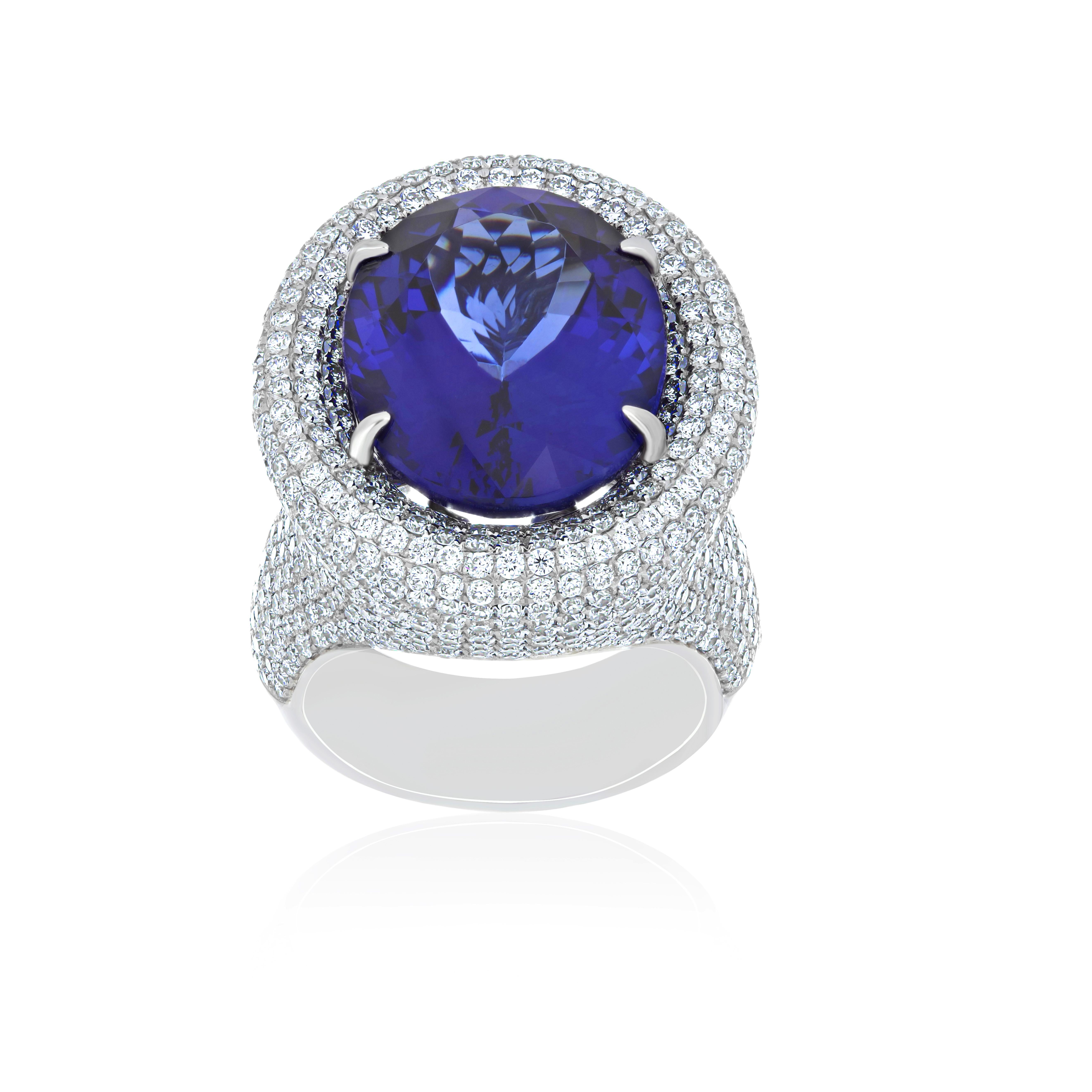Elegant and Exquisitely detailed White Gold Ring, with a rare 16.95 Cts (approx.) Oval Shape Cut Tanzanite set in the center beautifully accented with Micro pave set Diamonds, weighing approx. 4.9 CT's (approx.). total carat weight to further