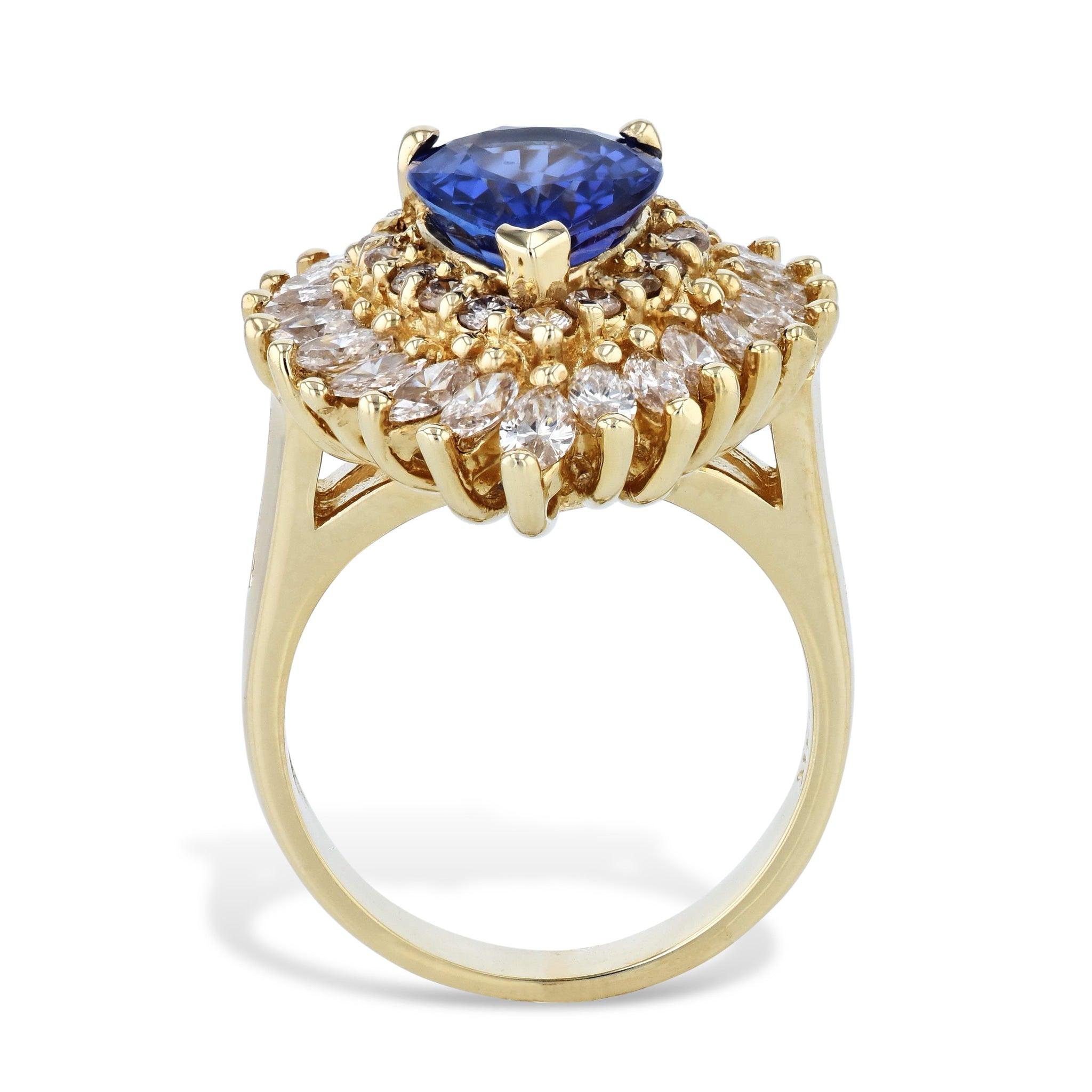 Be captivated by the luxurious beauty of this Tanzanite Diamond Yellow Gold Estate Ring. Crafted with 14kt. yellow gold, this piece radiates sophistication with a 2.90ct Tanzanite in its center and 23pcs Marquise shape Diamondsand 16pcs Round