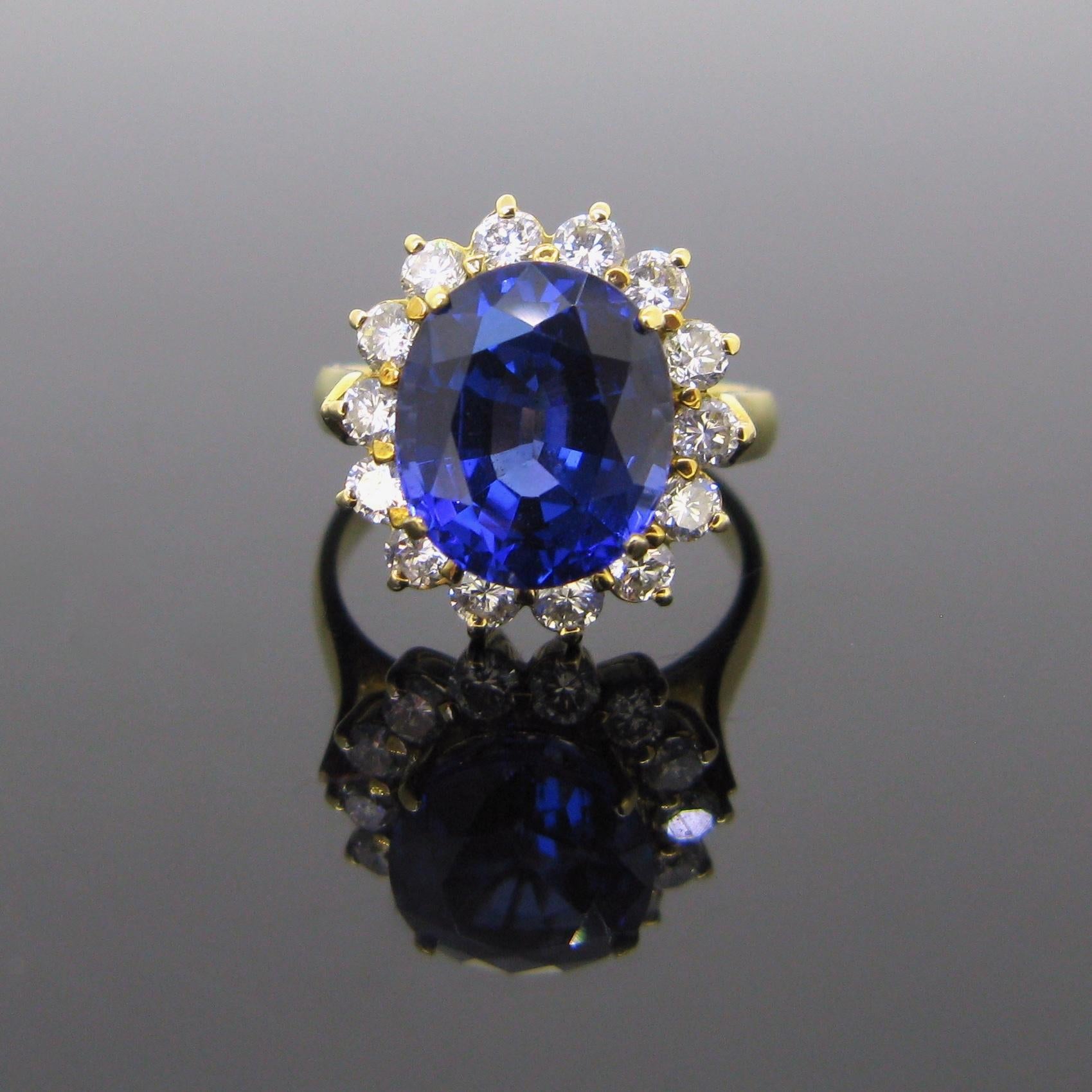 This ring is set in its center with a nice deep bluish purple tanzanite of 5,30ct approximately. It is surrounded with 14 brilliant cut diamonds. There is an approximate carat weight of 1,20ct (H/VS).  It is a size 51 - 5 1/4- K 1/4 and could be