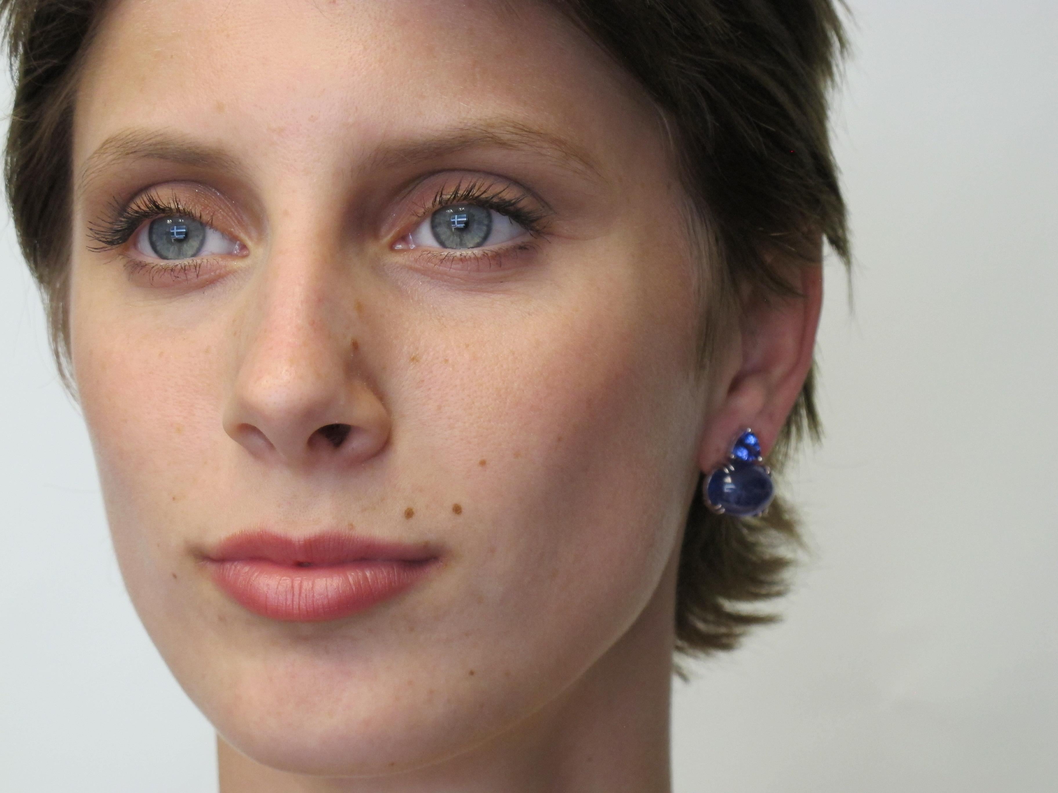 Unusual & beautiful! These 18k gold earrings contain Tanzanite cabochons (22.23cts/16 x 12 mm) and facetted trilliant-cut Tanzanites (1.90cts/6.5 x 6.5 mm). They hug the earlobes beautifully and are very flattering to the lucky wearer.

Handmade by