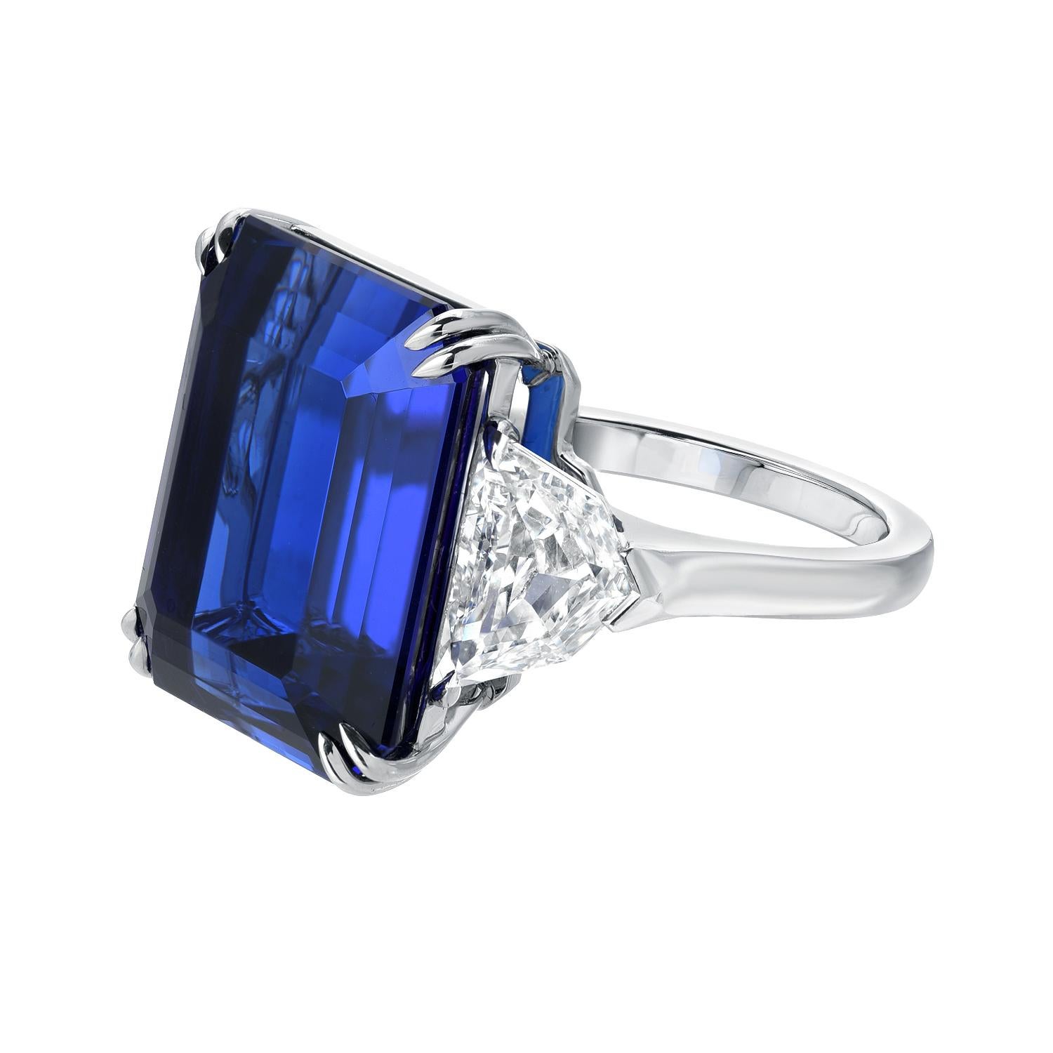 This unmatched 20.51 carat emerald cut Tanzanite, flanked by a pair of 2.04 carats total F/VS2 Diamonds, is hand set in this extraordinary hand crafted platinum ring. The combination of its rich vivid blue hue, strong saturation, complimented by its