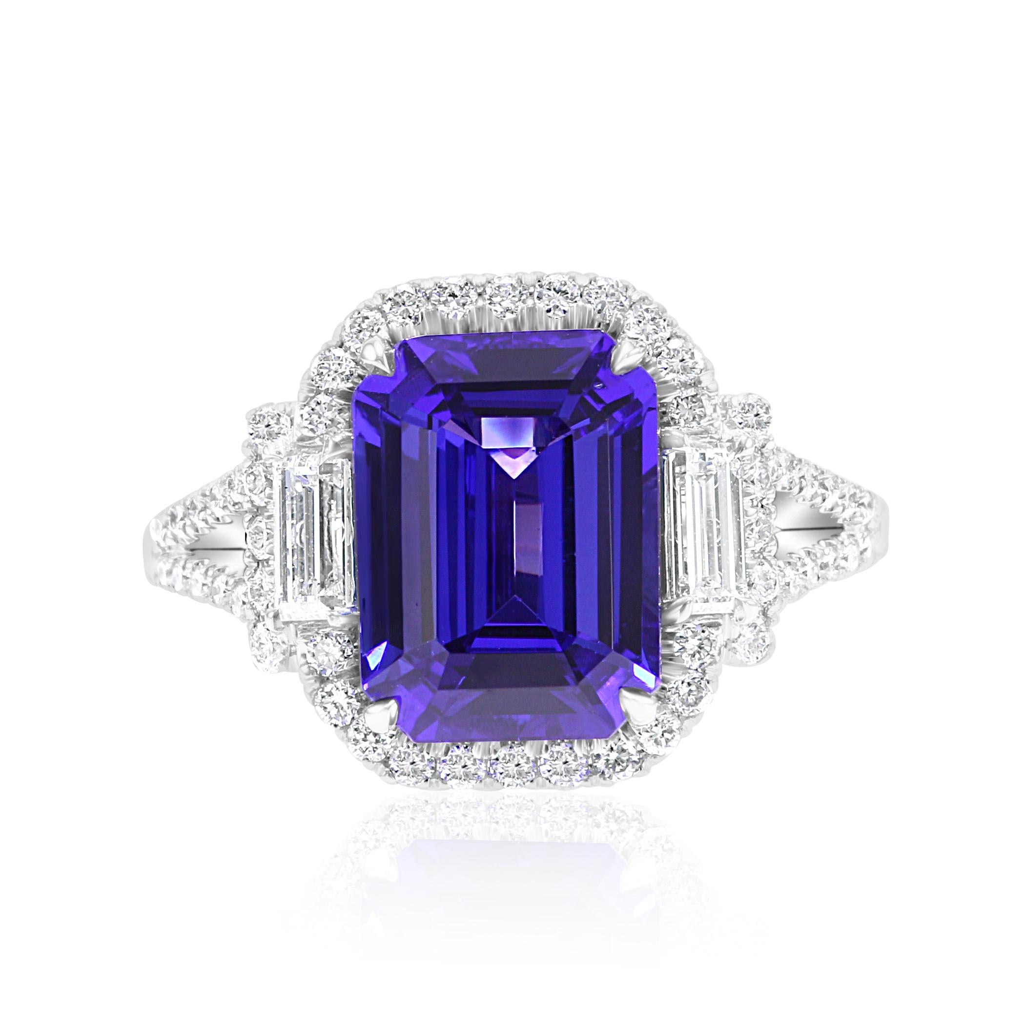 Stunning Tanzanite Emerald Cut 4.45 Carat Flanked with 2 White GH Color Diamond Baguette VS-SI clarity 0.38 Carat. Encircled in a single Halo of White GH color VS-SI clarity Diamond Rounds 0.65 Carat in gorgeous Hand Crafted in 18K White Gold. Can