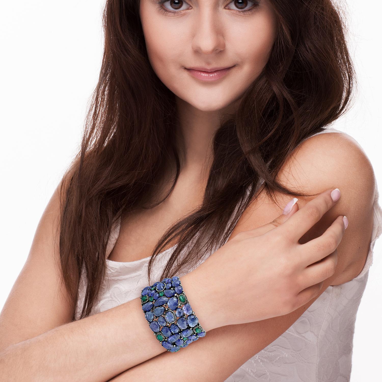 Cast from 18K gold and sterling silver.  Bold and distinctive, a stunning statement cuff set in 155.04 carats tanzanite, 10.79 carats emerald & 2.86 carats of diamonds. Pair this with your favorite evening dress for a red carpet look. Clasp Closure
