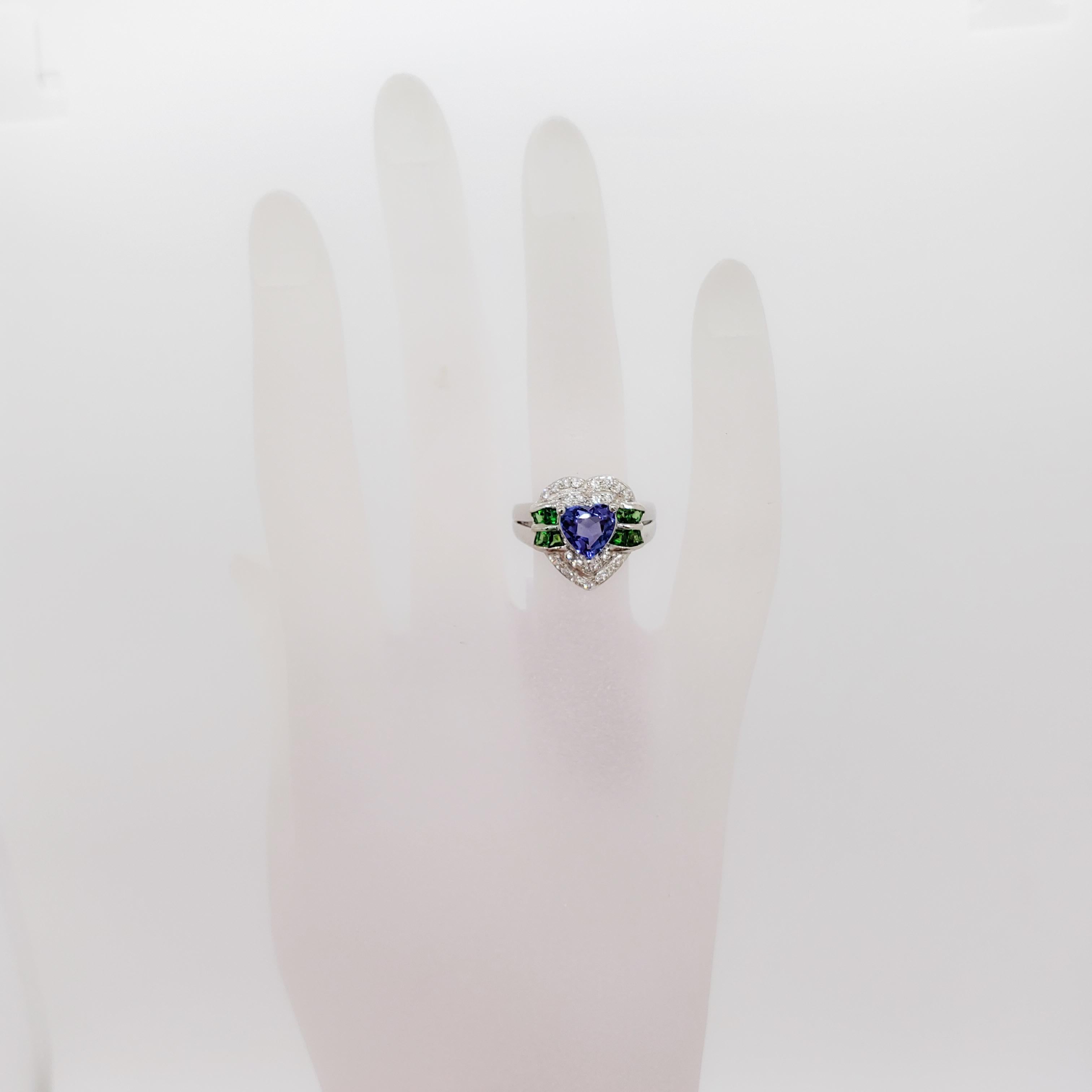 Beautifully designed and well made ring featuring a 1.10 ct. tanzanite heart with a nice deep blue purple color and 1.28 ct. of green garnet squares and white diamond rounds.  Handmade in platinum.  Ring size 6.  Such a fun and flirty piece.