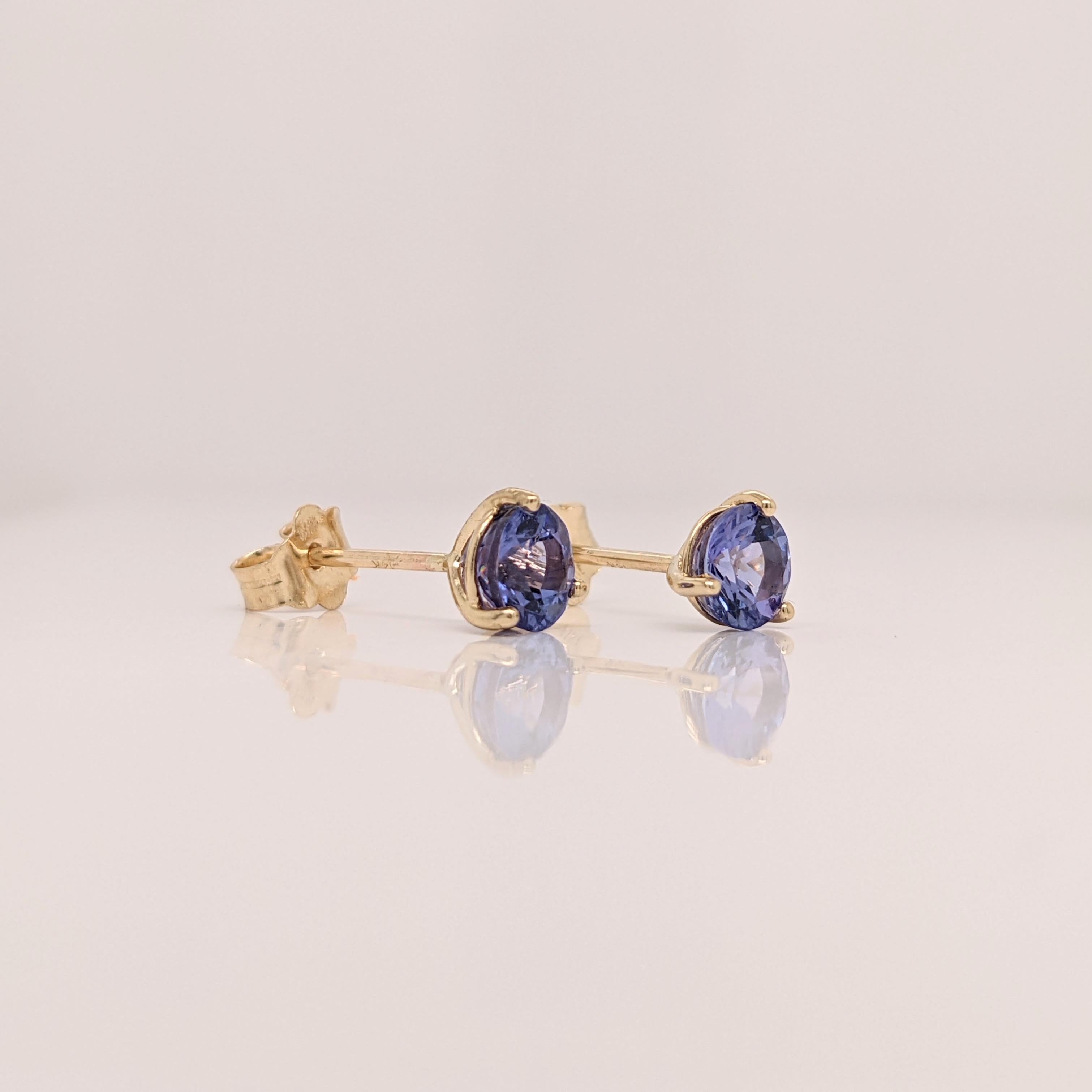 These elegant earrings feature round tanzanite stones, exuding a captivating violet-blue hue. The stones are securely set in a classic martini setting, allowing their brilliance to shine. A timeless solitaire design, perfect for adding a touch of