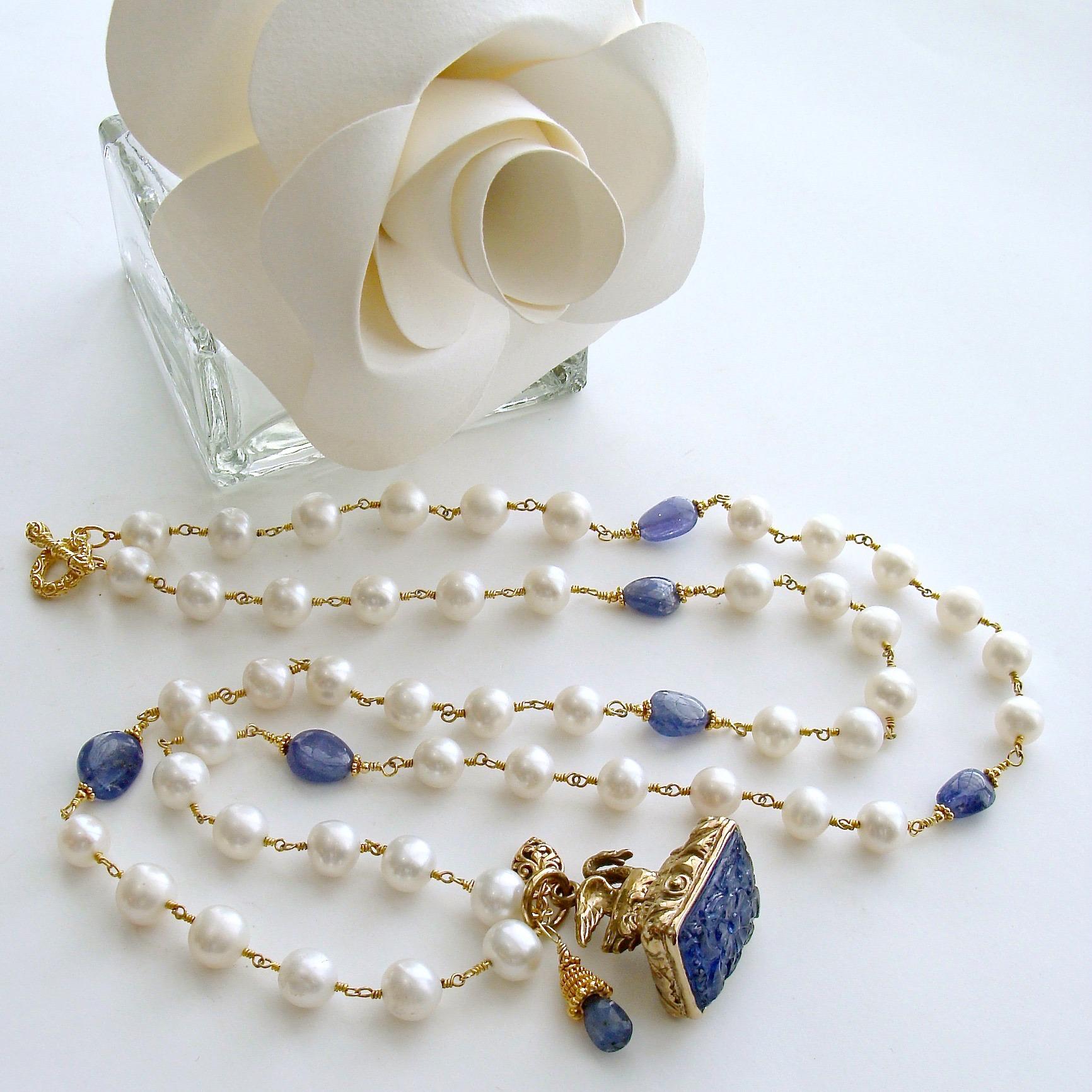 Étaín II Necklace.

A luxe hand-linked chain of creamy freshwater pearls is intercepted with smooth, deep periwinkle colored tanzanite nuggets, stationed along the chain.  The focal point of this necklace is a faithfully reproduced Georgian swan