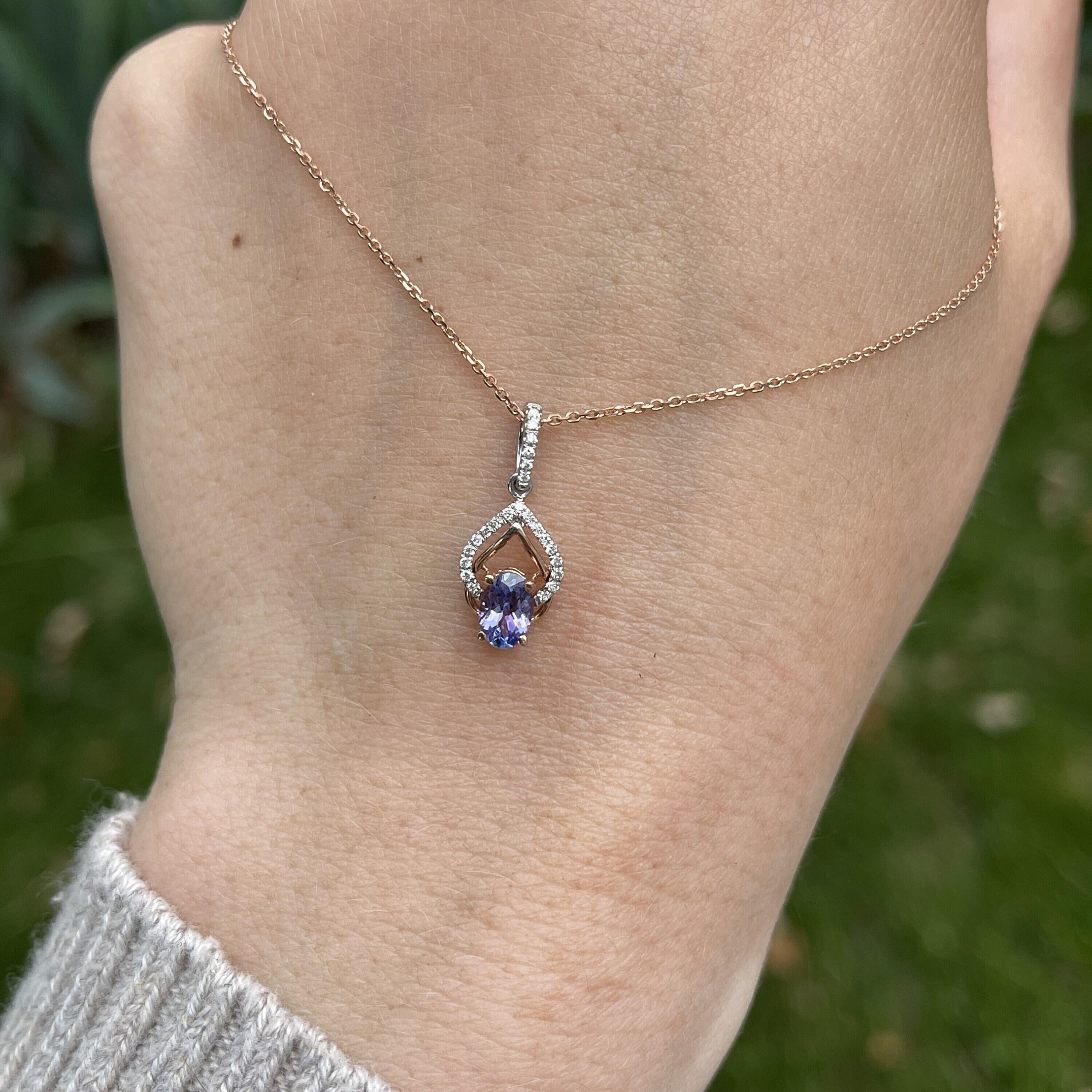 This gorgeous oval tanzanite has beautiful flashes of red and purple accentuated in this solid gold dual-tone setting. The earth mined natural diamonds add an extra sparkle on this petite but intricate pendant. A beautiful something blue, or