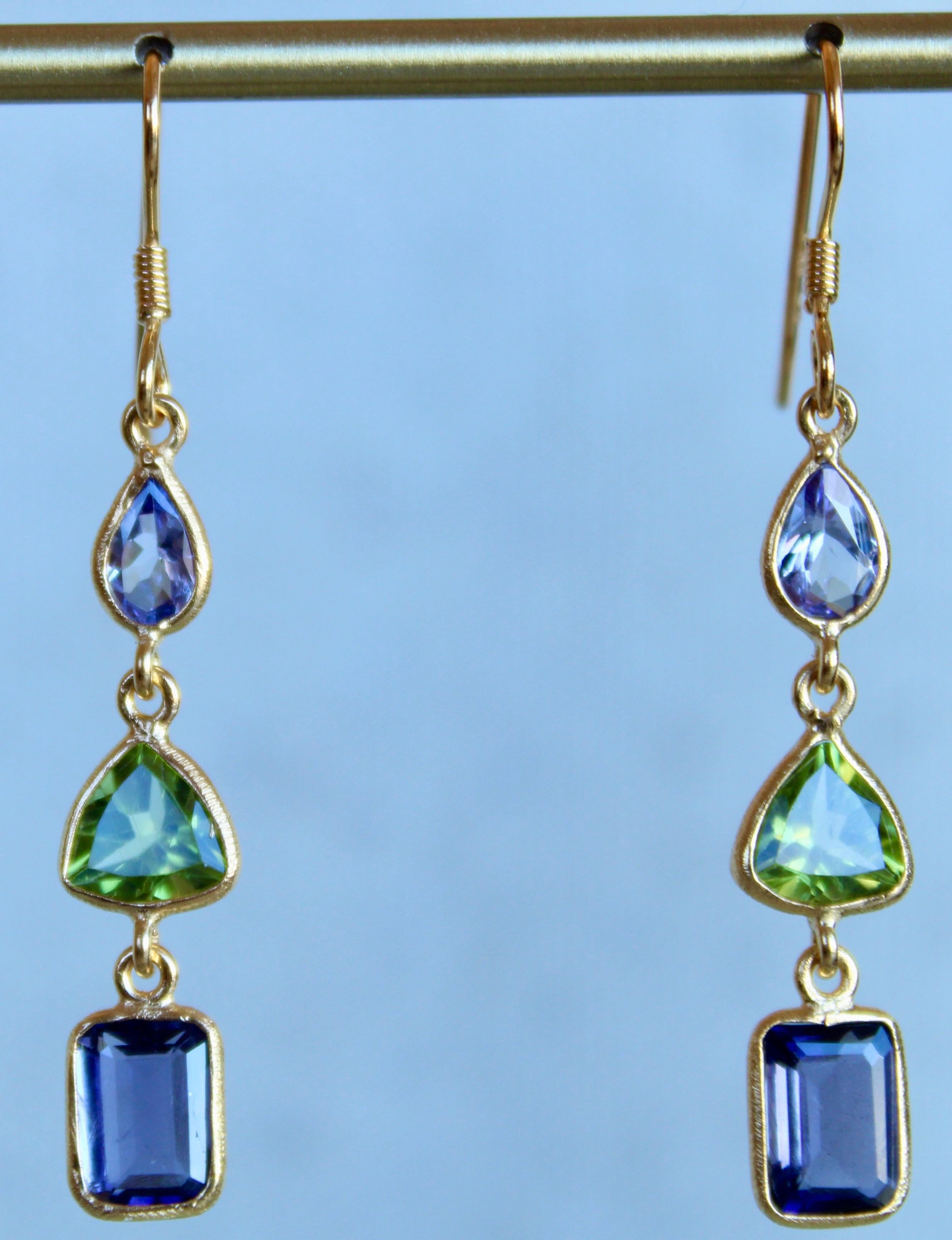 The earrings are comprised of Tanzanite pears, which display rich hues of sky blue, green Peridot trillions and deep navy Iolite emerald cut stones. These earrings are designed to be worn as a pair or as a single. Each gemstone is hand sourced in