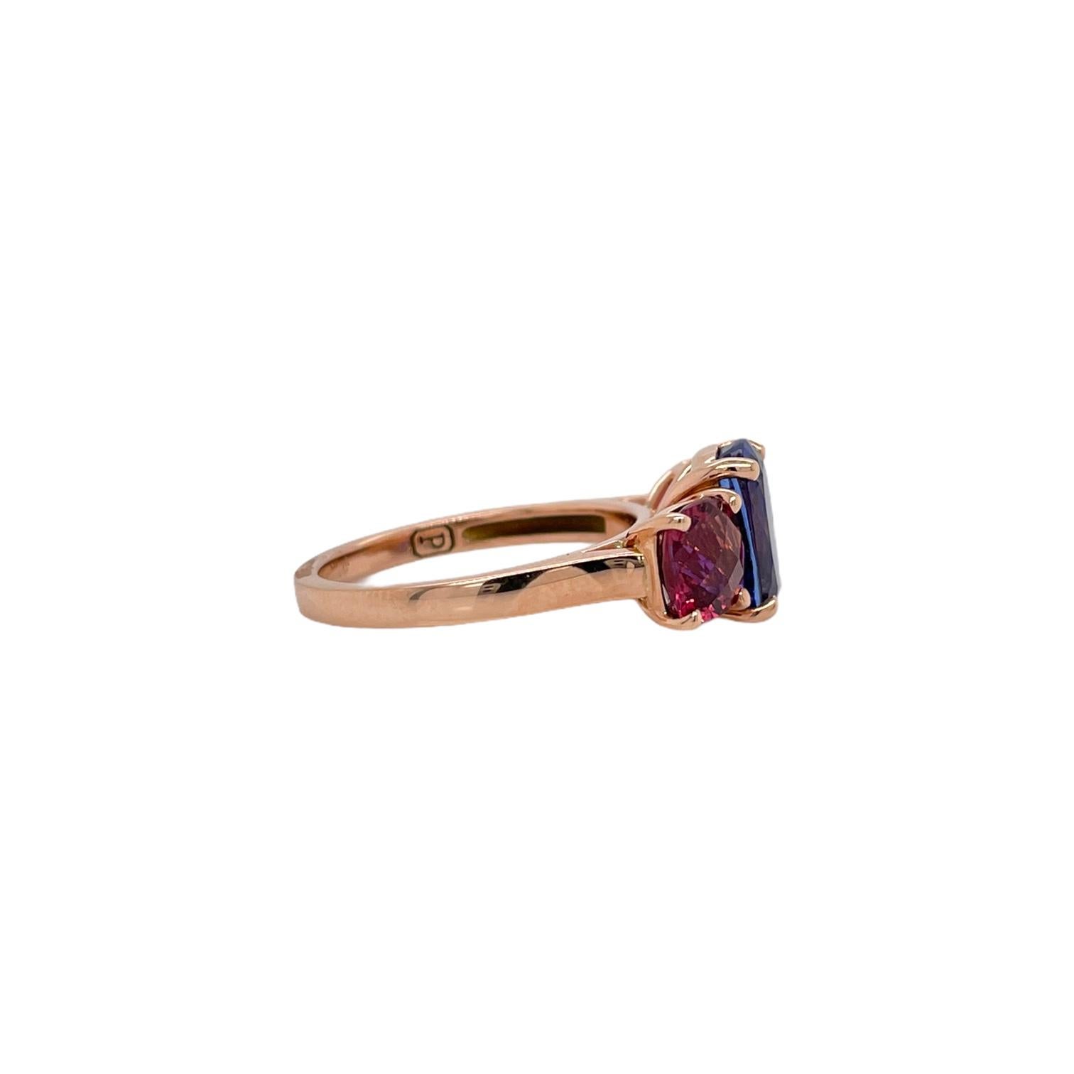 Modern tanzanite and pink tourmaline three stone ring in 14k rose gold. Ring contains 1 finely cut cushion shape tanzanite 3.06ct and 2 precisely matched square cushion shape pink tourmalines 1.85tcw. Stones are mounted in a basket style prong