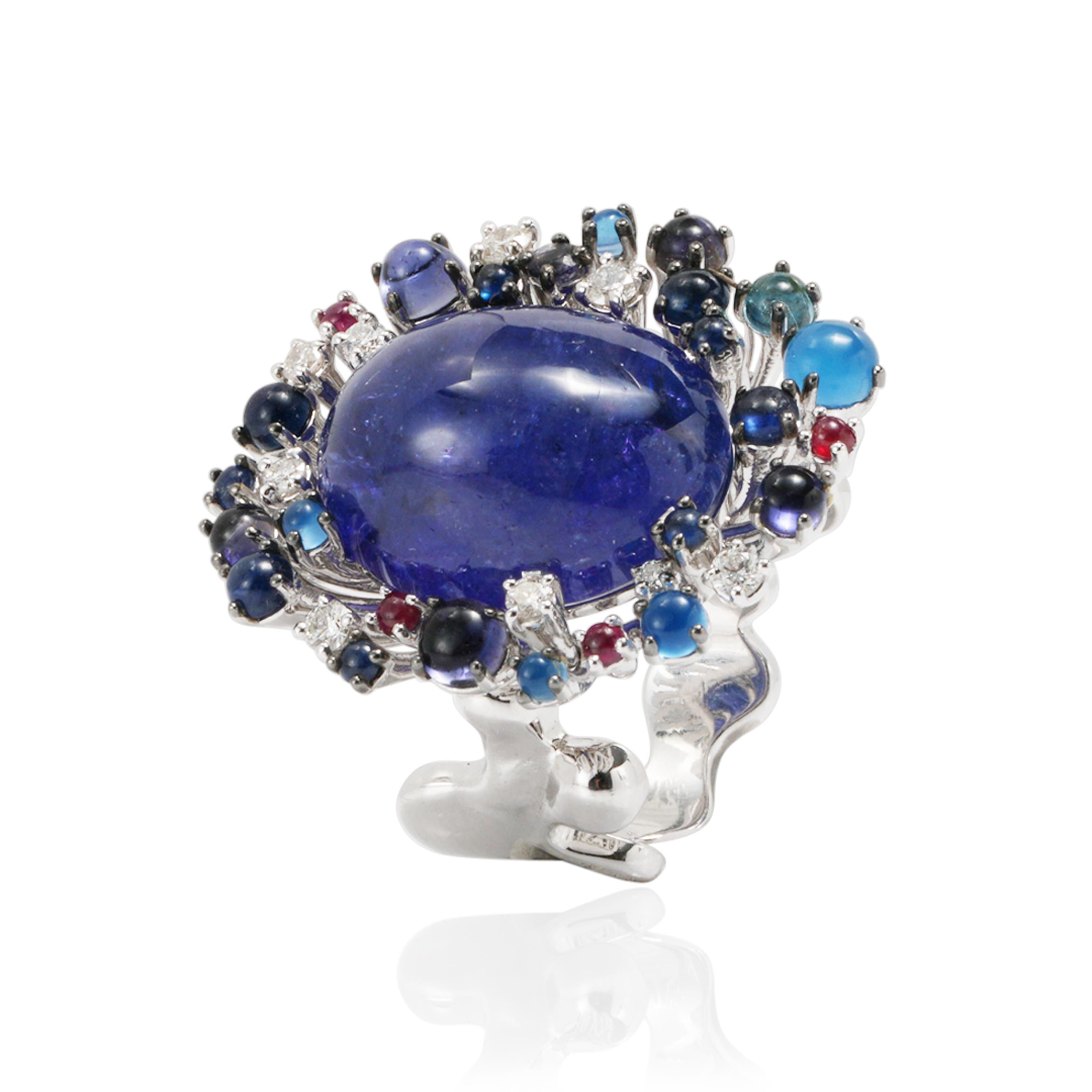 Cabochon cut tanzanite ring created in white gold 18k with diamonds and precious stones: topaz, sapphires, iolites, agate and rubies.
A one of a kind piece from Masterpieces collection signed by DAVERIO1933. 