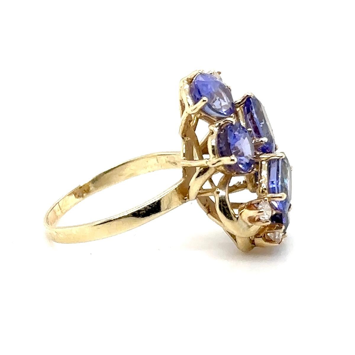 14k yellow gold ring with 6 oval natural tanzanites weighing approximately 10.00 carats and 4  round brilliant diamonds weighing approximately 0.15 carats.