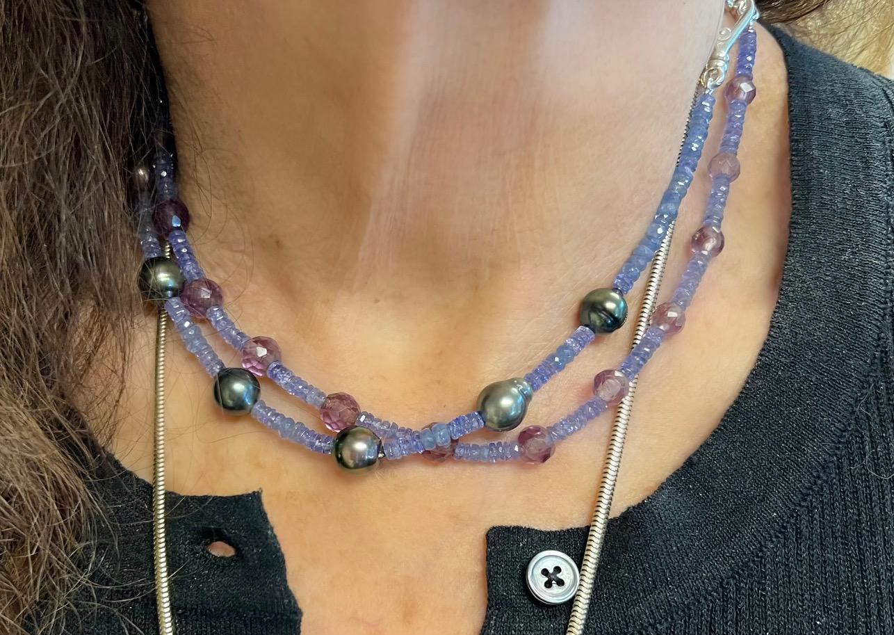 Immerse yourself in the captivating elegance of this exquisite necklace, featuring a harmonious blend of tanzanite, blue sapphire beads, and baroque black Tahitian pearls. Each element is thoughtfully selected and meticulously arranged to create a