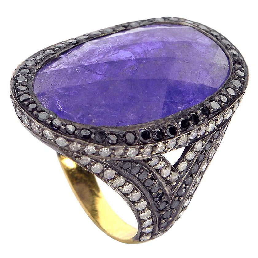 Anello con fetta di tanzanite circondata da diamanti bianchi e neri