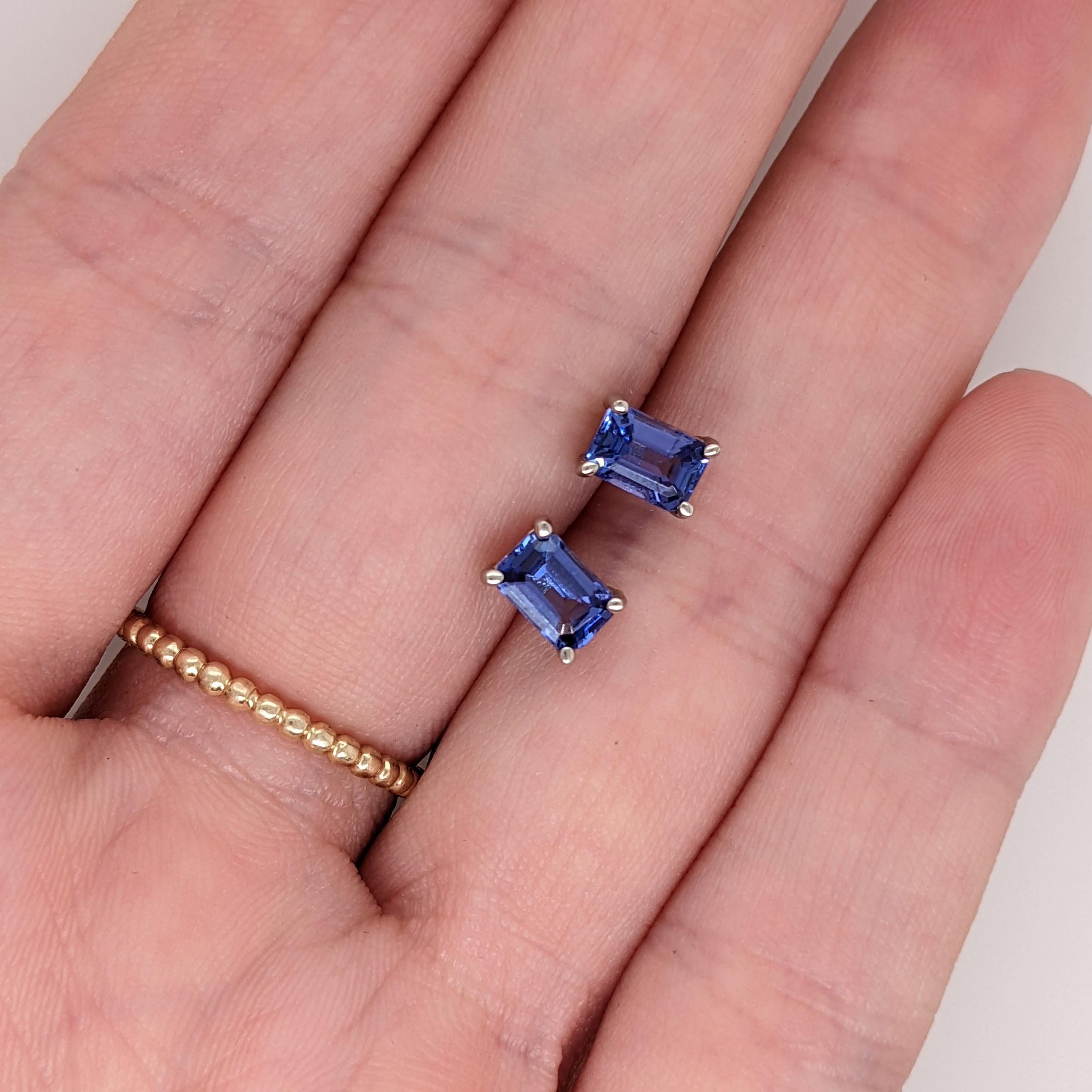 These elegant earrings feature emerald cut tanzanite stones, exuding a captivating violet-blue hue. The stones are securely set in a four prong setting, allowing their brilliance to shine. A timeless solitaire design, perfect for adding a touch of