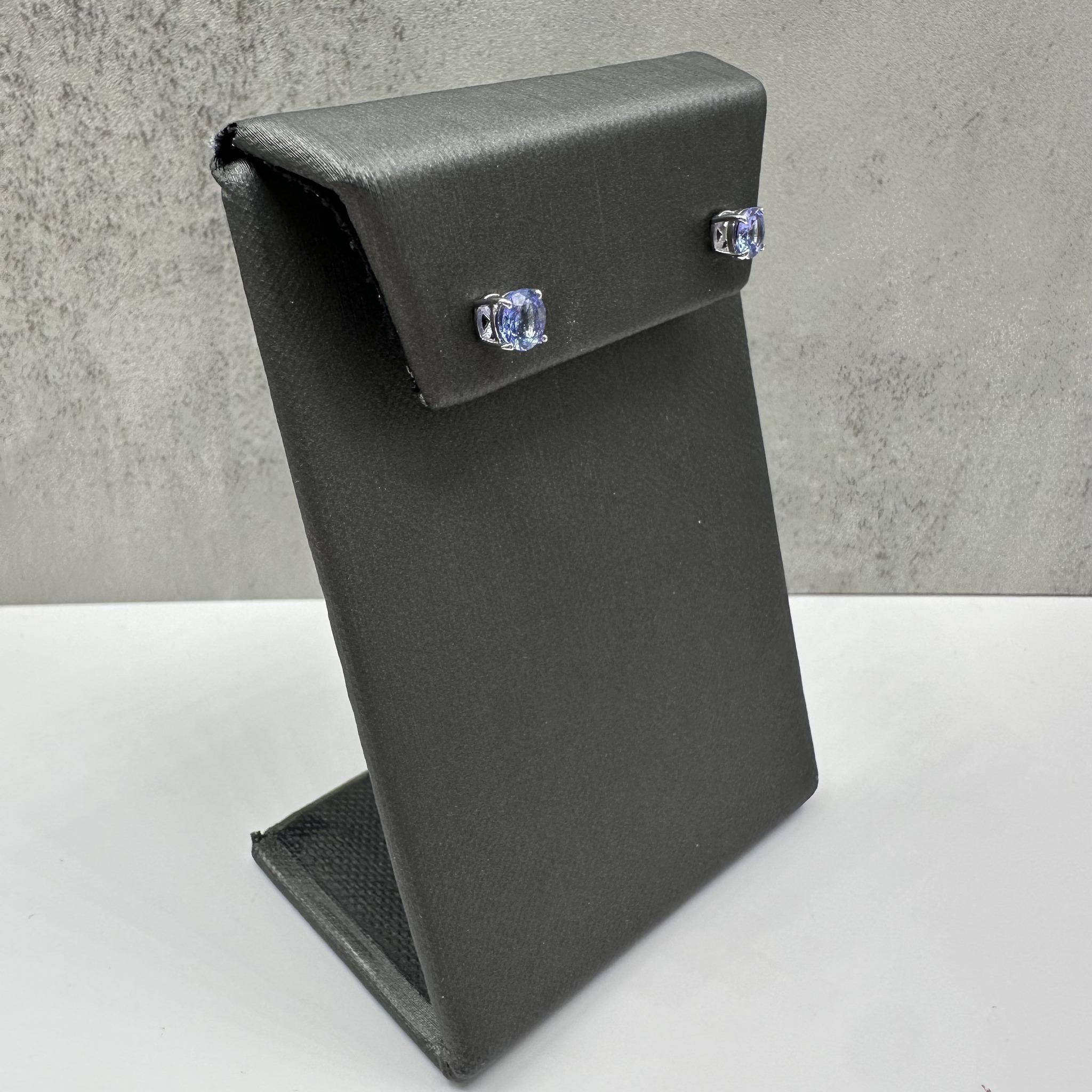 Diese eleganten Tansanit-Ohrstecker aus 10-karätigem Weißgold sind mit ca. 4,9-5 mm großen, natürlichen, runden Tansaniten besetzt, die in einer klassischen 4-Zacken-Korbfassung mit sicheren Druckknöpfen gefasst sind. Mit einem Gewicht von nur 0.8