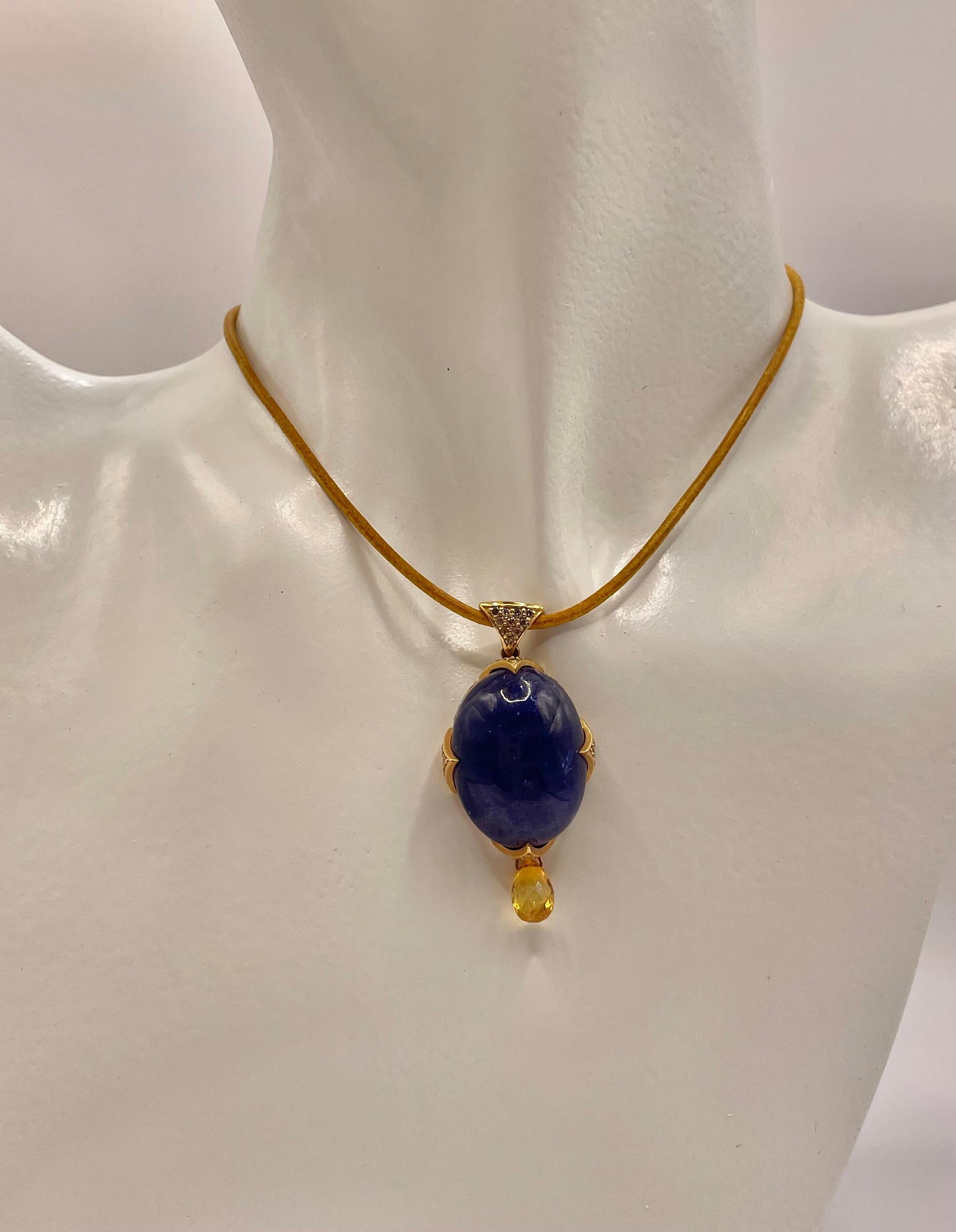 One of a kind ! 28 ct cabochon Tanzanite and 0.7 ct yellow sapphire briolette  set in 18k gold with 0.69 ct champagne diamonds.On yellow Italian leather cord that  can be tie at the back .