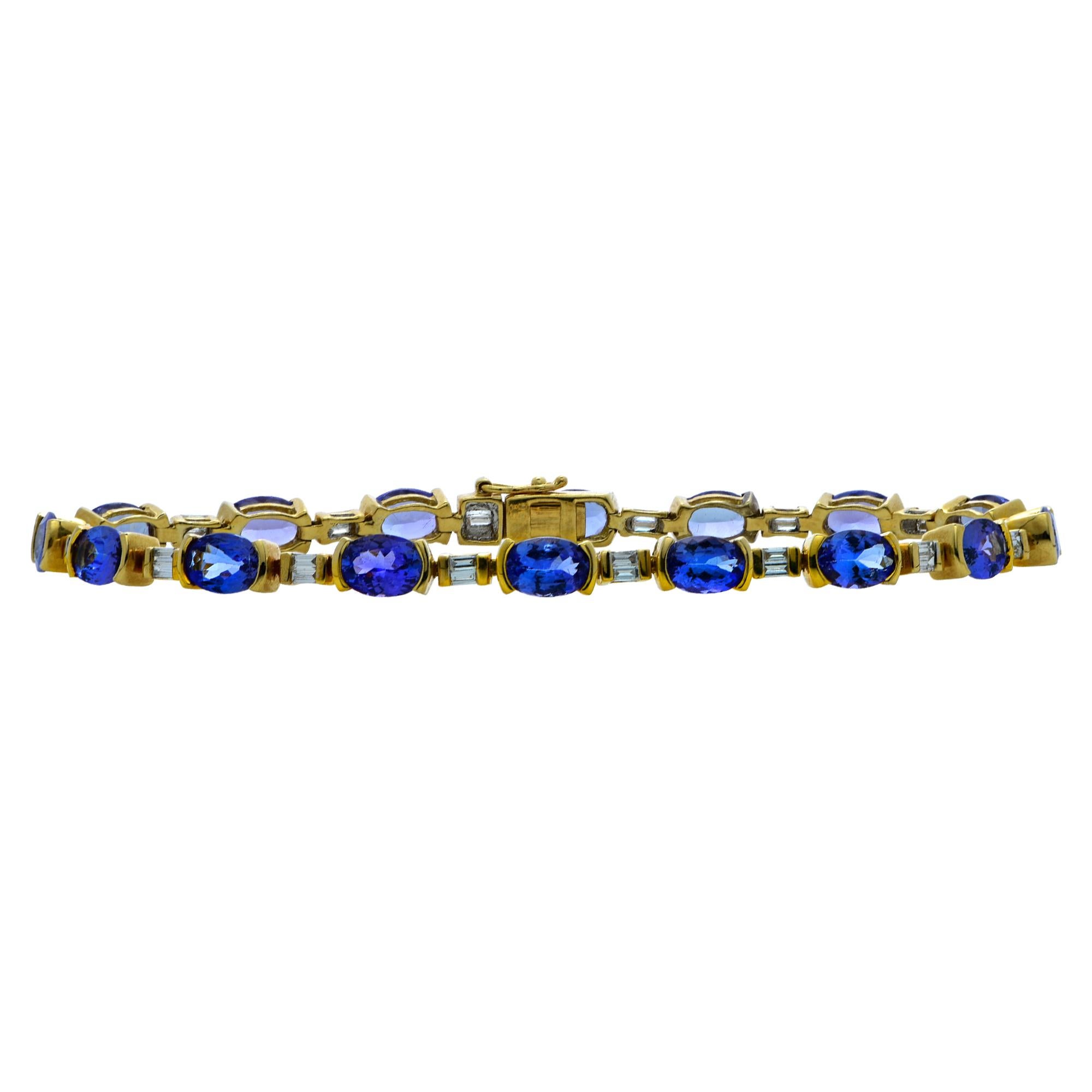Striking bracelet crafted in 18 karat yellow gold showcasing 16 oval shape tanzanites weighing approximately 8 carats total and 32 baguette cut diamonds weighing approximately .80 carats total. The diamonds and tanzanites are set in an alternating