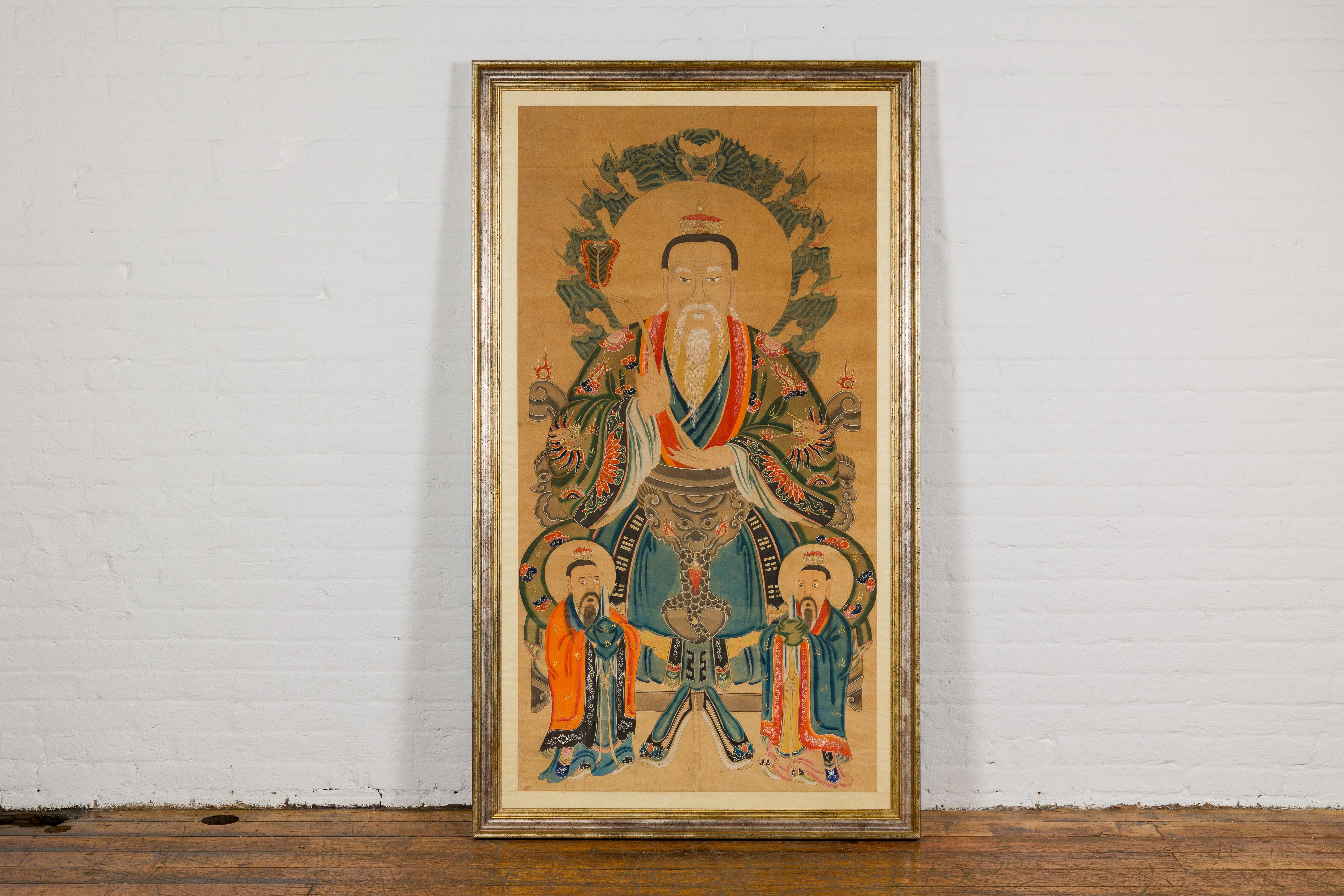 A large antique hand-painted Taoist portrait on parchment paper with silk matting, in custom frame. This large antique hand-painted Taoist portrait is a mesmerizing work of art that encapsulates centuries of tradition and symbolism. Painted on