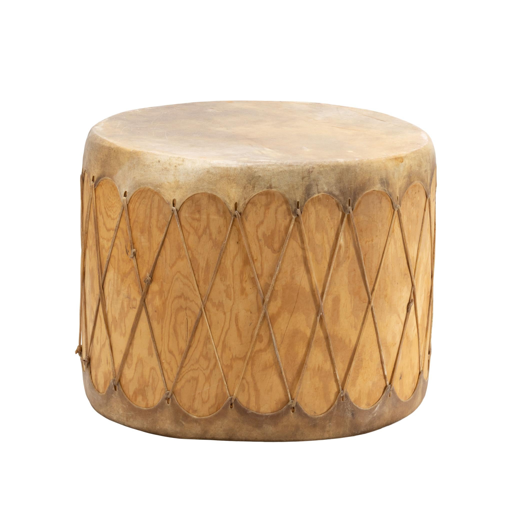 Taos Pueblo pow wow drum with beaters. The drum's wooden body is made of hollowed-out cottonwood over which a tight drum head of animal skin is stretched. Hide is attached with criss-cross rawhide lacing with nice patina from use. Natural colors,