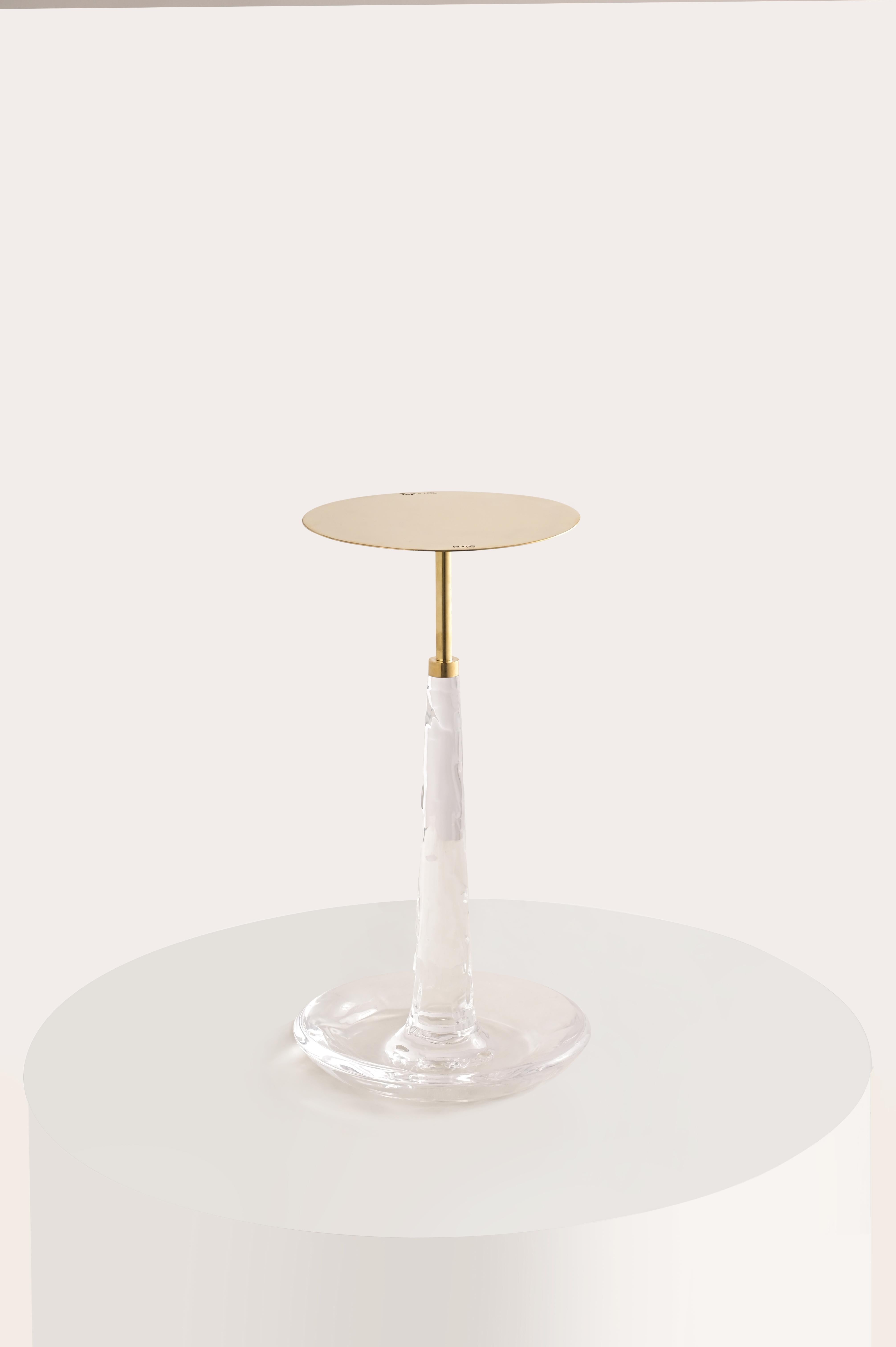 Voici la table d'appoint Tap, une touche d'art prête à rehausser votre espace. Fabriquée en laiton et en acrylique, cette pièce fantaisiste s'inspire d'un robinet et de l'eau qui s'en écoule, mêlant des matériaux contrastés en une création