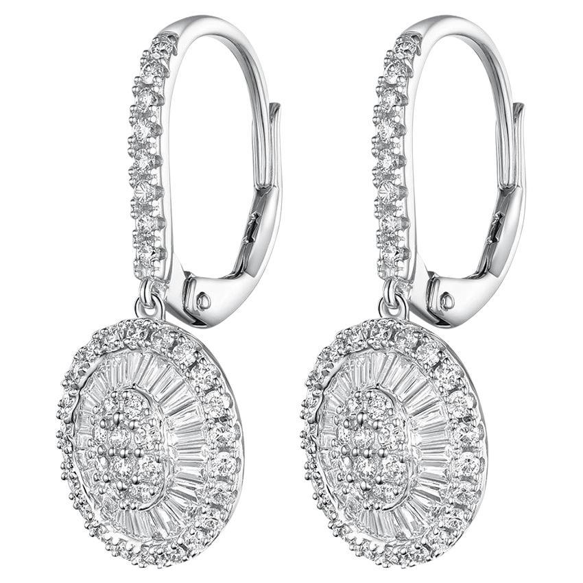 These are luxurious drop earrings crafted from 14 karat yellow gold, exuding opulence and craftsmanship. Each earring showcases a concentric circle design, with the inner circle featuring taper baguette diamonds that radiate outward like sunbeams,
