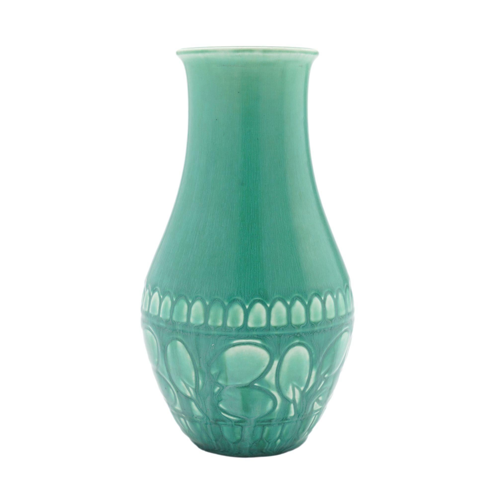 Tapered bulb form vase finished in a medium green drip vellum glaze over a shallow impressed design on the lower half of the vase. The vase has a 2-1/2