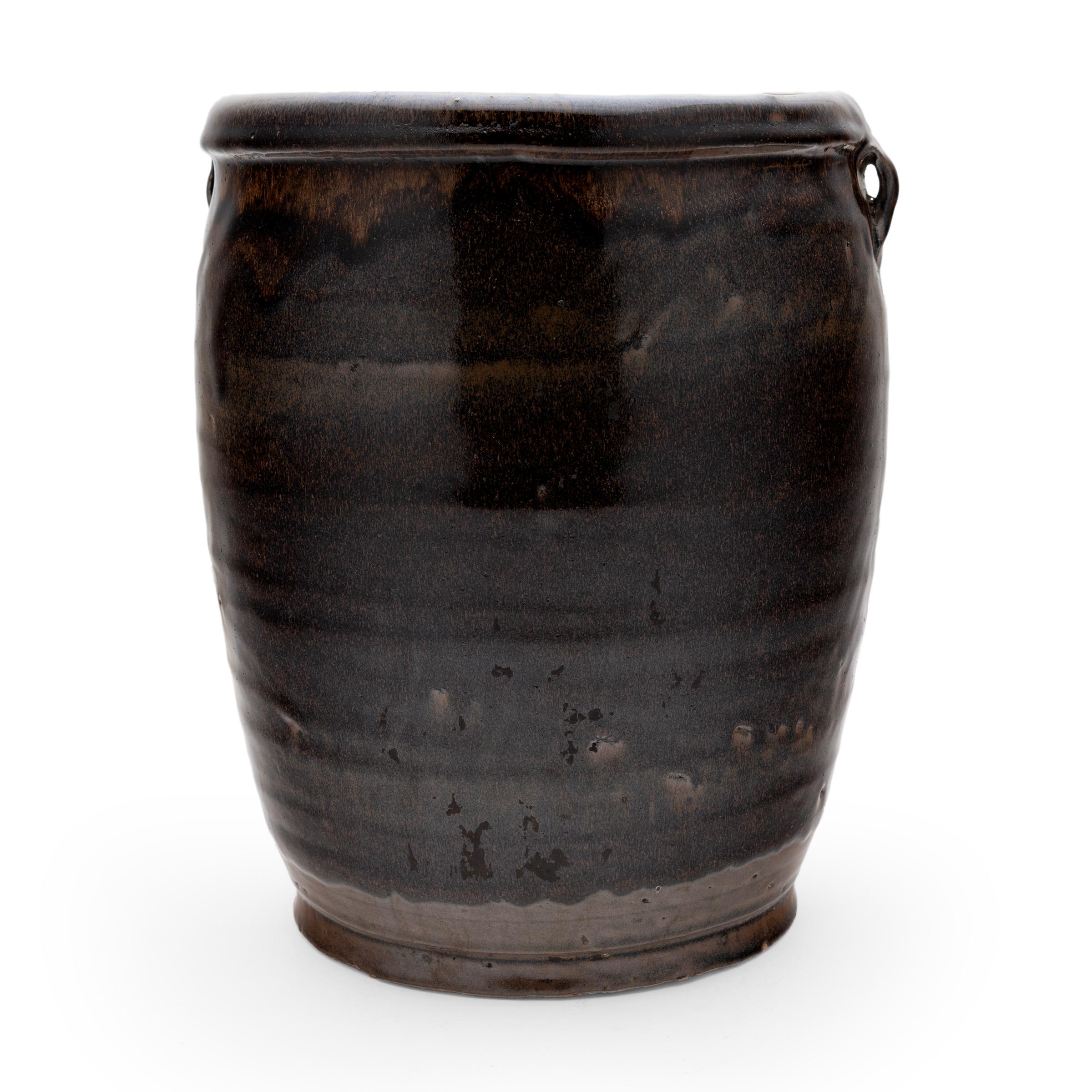 A speckled, dark brown glaze coats the gently tapered form of this late 20th century kitchen jar. As evidenced by the glazed interior, the jar was once used daily in a Qing-dynasty kitchen for fermenting foods and condiments. The wide-mouth jar