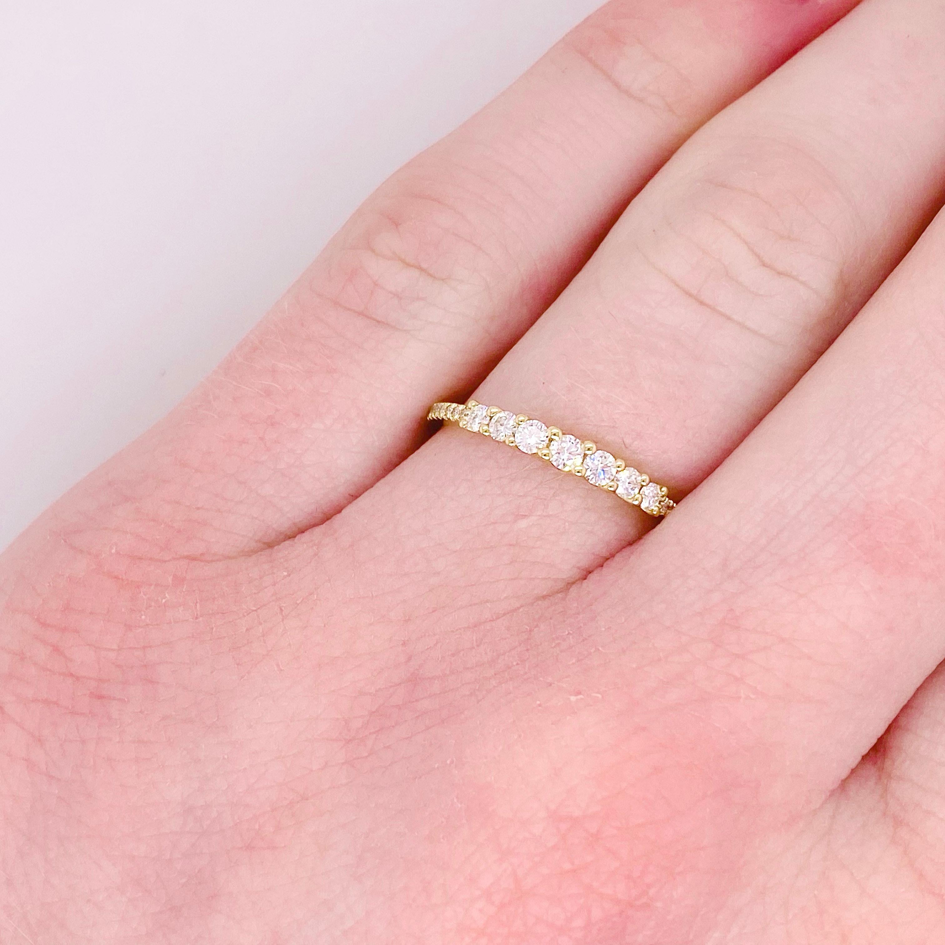 This diamond band takes a unique twist to the classic look. Round diamonds taper from the center and a straight line of small diamonds are added on either side. This versatile band is perfect to highlight an engagement ring to to add to a custom