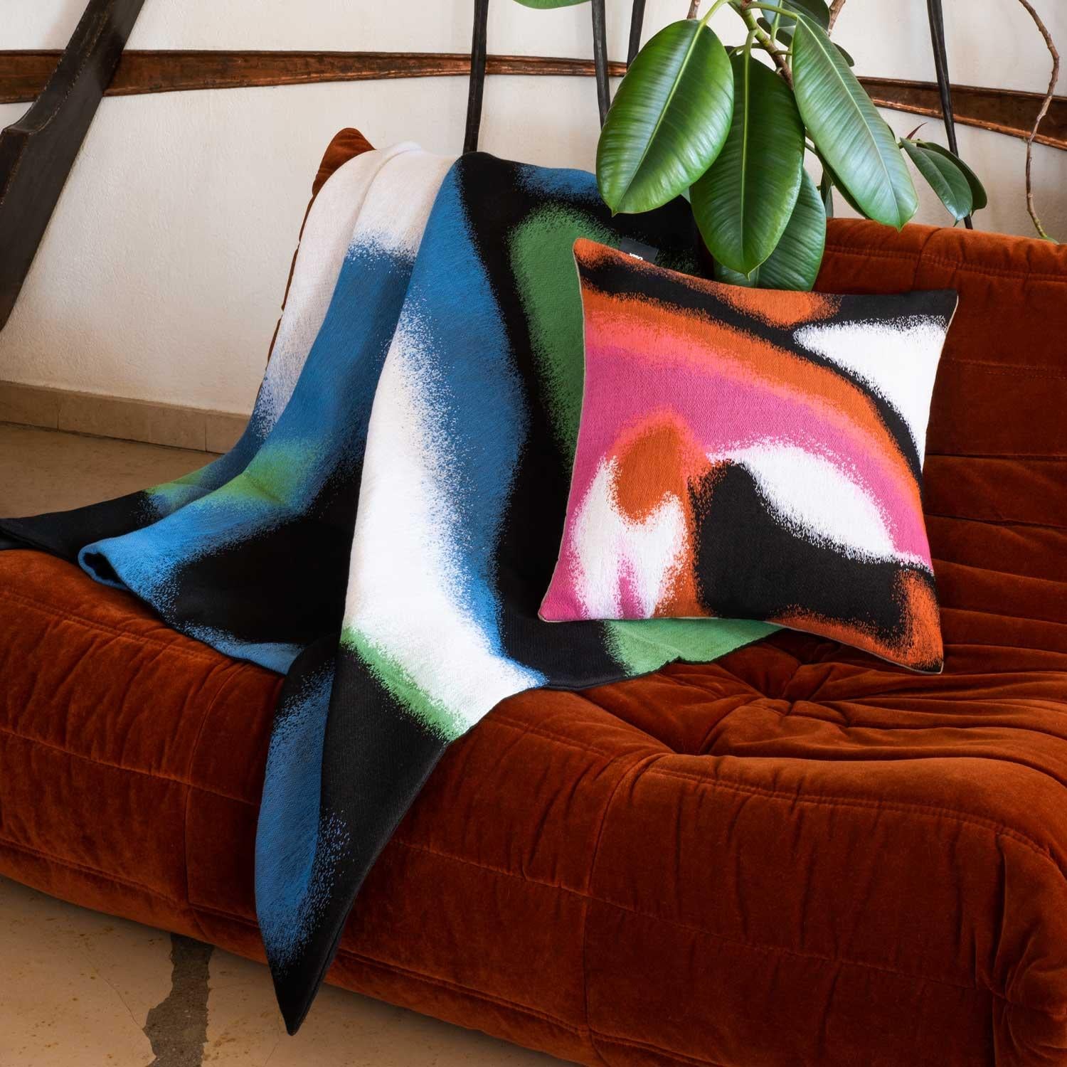 Our tapestry blankets turns textile to art. A meticulously crafted three-layer jacquard produced in France, this weave is finished expertly by hand to create a subtle three-dimensional effect. In either a groovy pink and red color combination or the