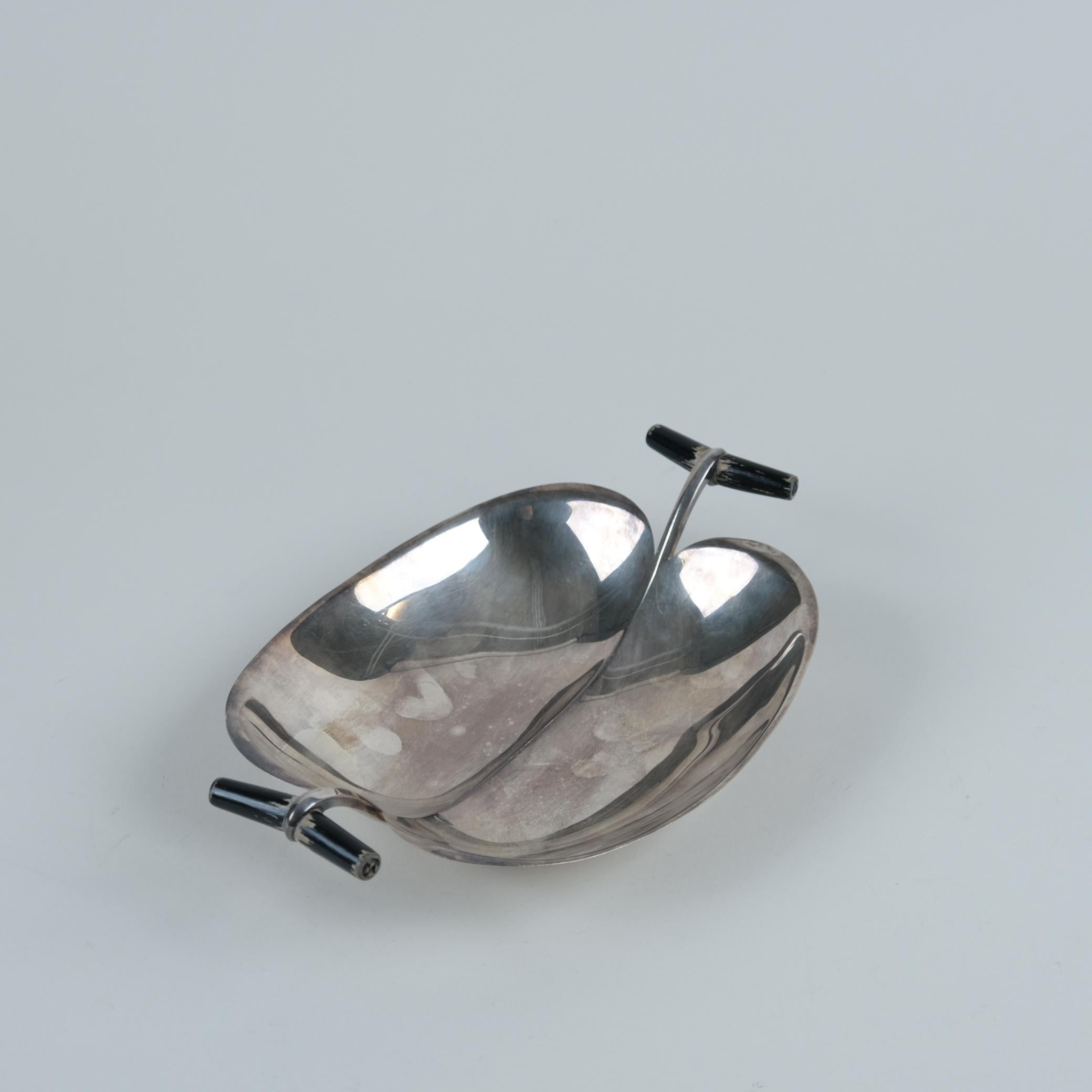 Plat Tapio Wirkkala modèle TW 58 en argent avec poignées en bouleau teinté noir, fabriqué dans les années 1950. Cette pièce présente l'un des nombreux et magnifiques designs de Wirkkala, qui ressemble presque à un coquillage. Le plat est entièrement