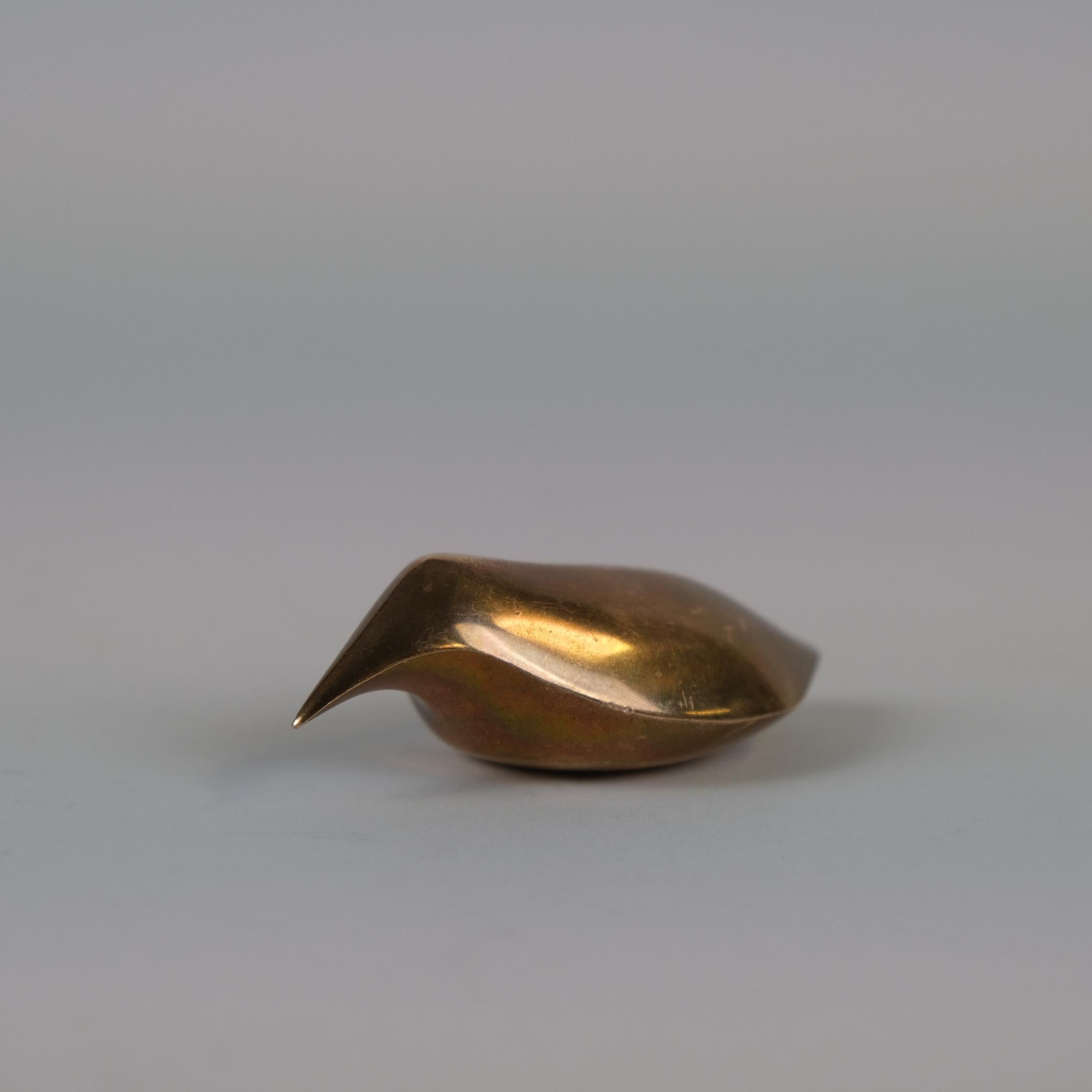 A beautiful example of Tapio Wirkkala's bird sculpture in solid brass. This minimalistic piece by Wirkkala, who started his career as a sculptor, objectifies his minimal organic approach to design by simplifying natural lines into abstract