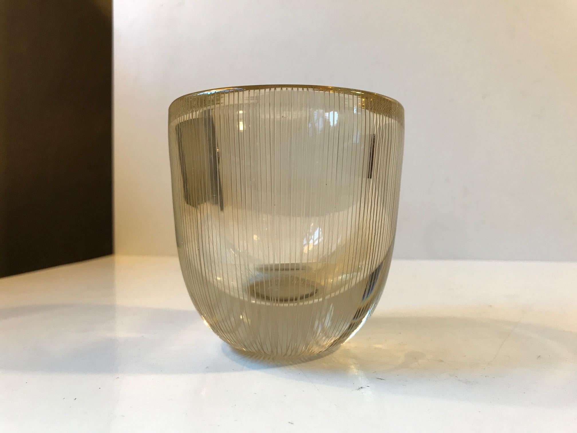 Clear slightly yellow-toned glass vase with vertical engraved lines. Designed by Tapio Wirkkala in Finland and manufactured by Littala in the early 1960s. The shape and tone of the glass is unusual. This piece is signed indistinguishable to the