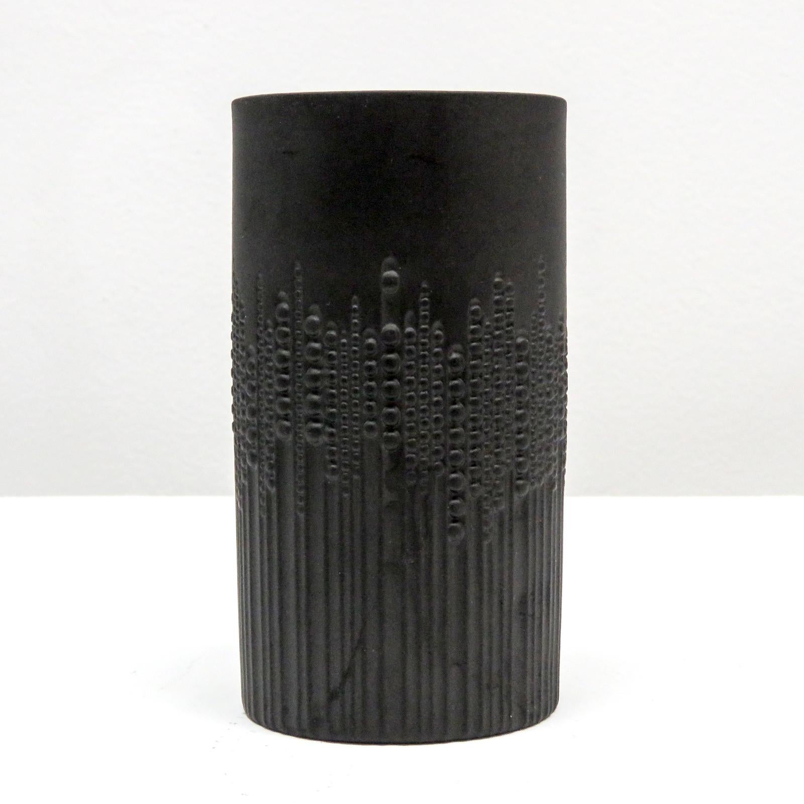 Wunderschöne zylindrische Vase aus schwarzem, mattem Porzellan, entworfen von Tapio Wirkkala für Rosenthal/Siemens, mit einem erhabenen Relief aus Perlen, die in vertikalen Linien verlaufen und den Eindruck von Bewegung vermitteln, gekennzeichnet.