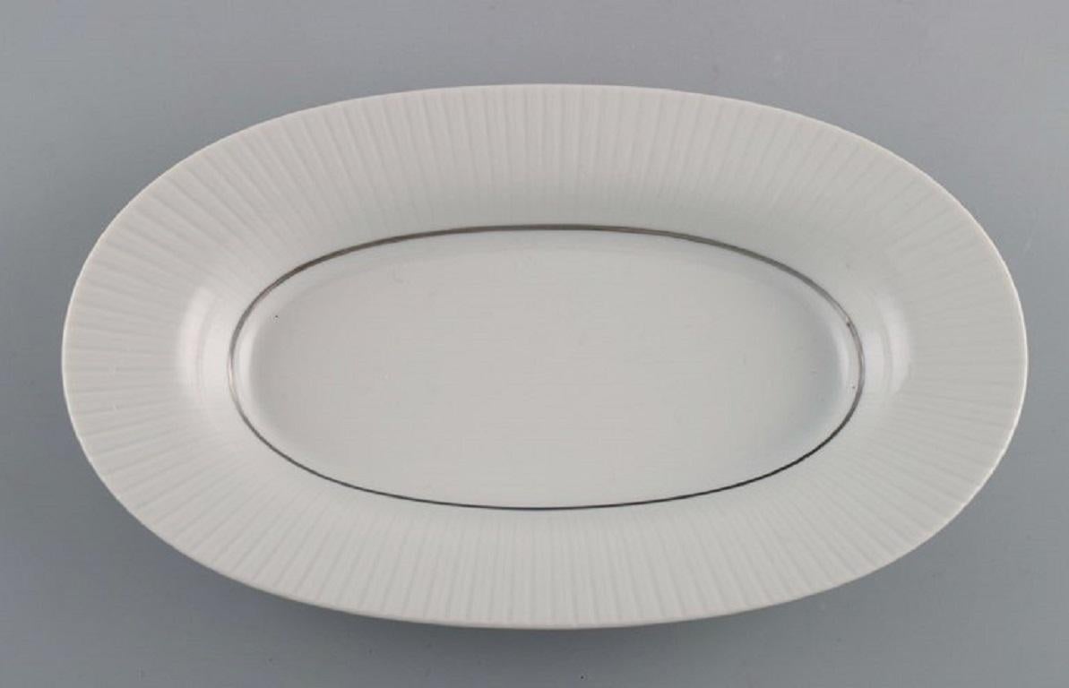 Tapio Wirkkala for Rosenthal. Rare Modulation salt shaker and dish / bowl in fluted porcelain. 
Platinum Detail. Classic and timeless design. 1960s.
The dish measures: 25 x 14 x 3.8 cm.
The salt shaker measures: 7 x 5.5 cm.
In excellent