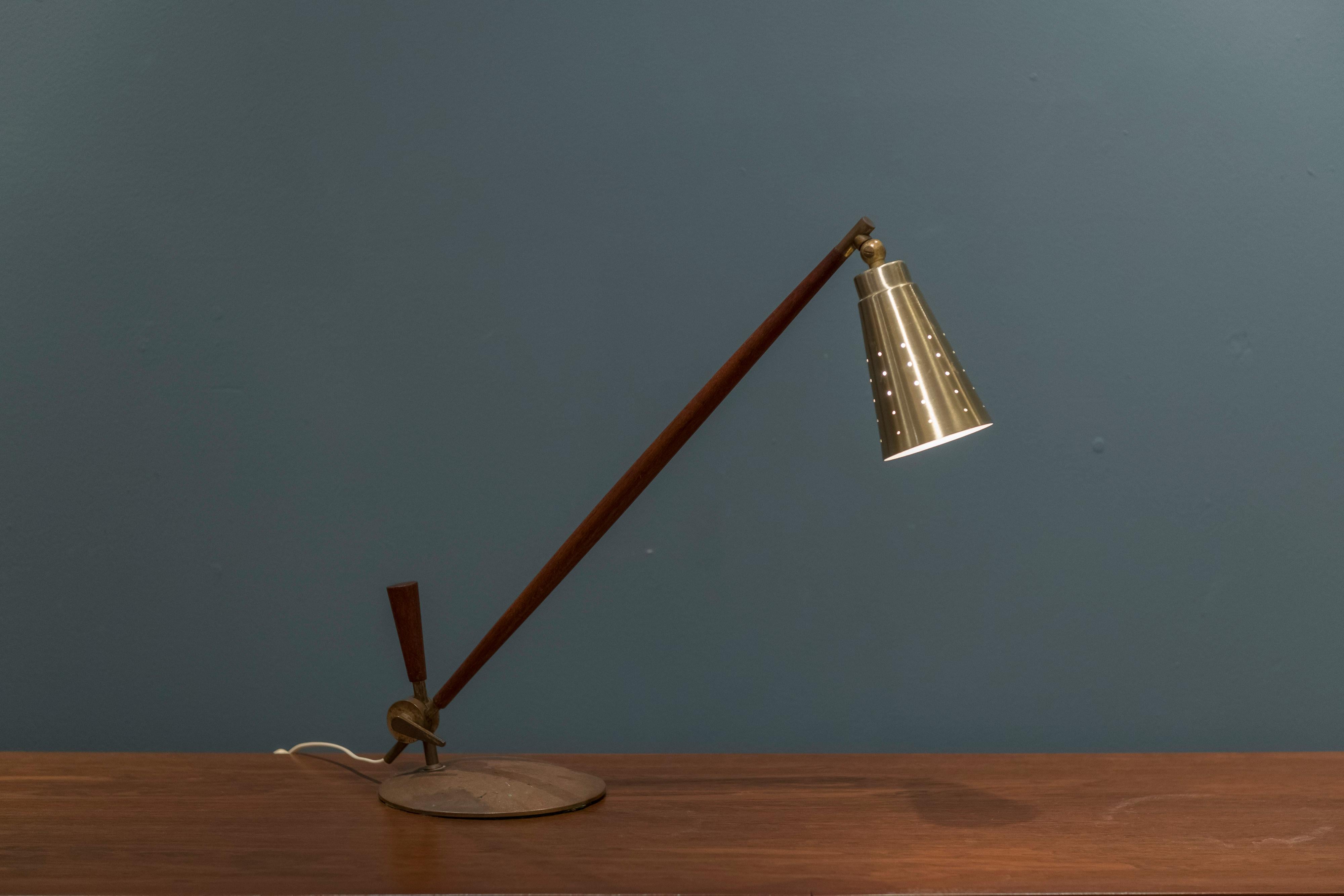 Tapio Wirkkala table lamp for Idman Oy, Finland. Pierced brass shade with teak and brass plated base and finishing’s. Lamp height is adjustable, newly rewired.