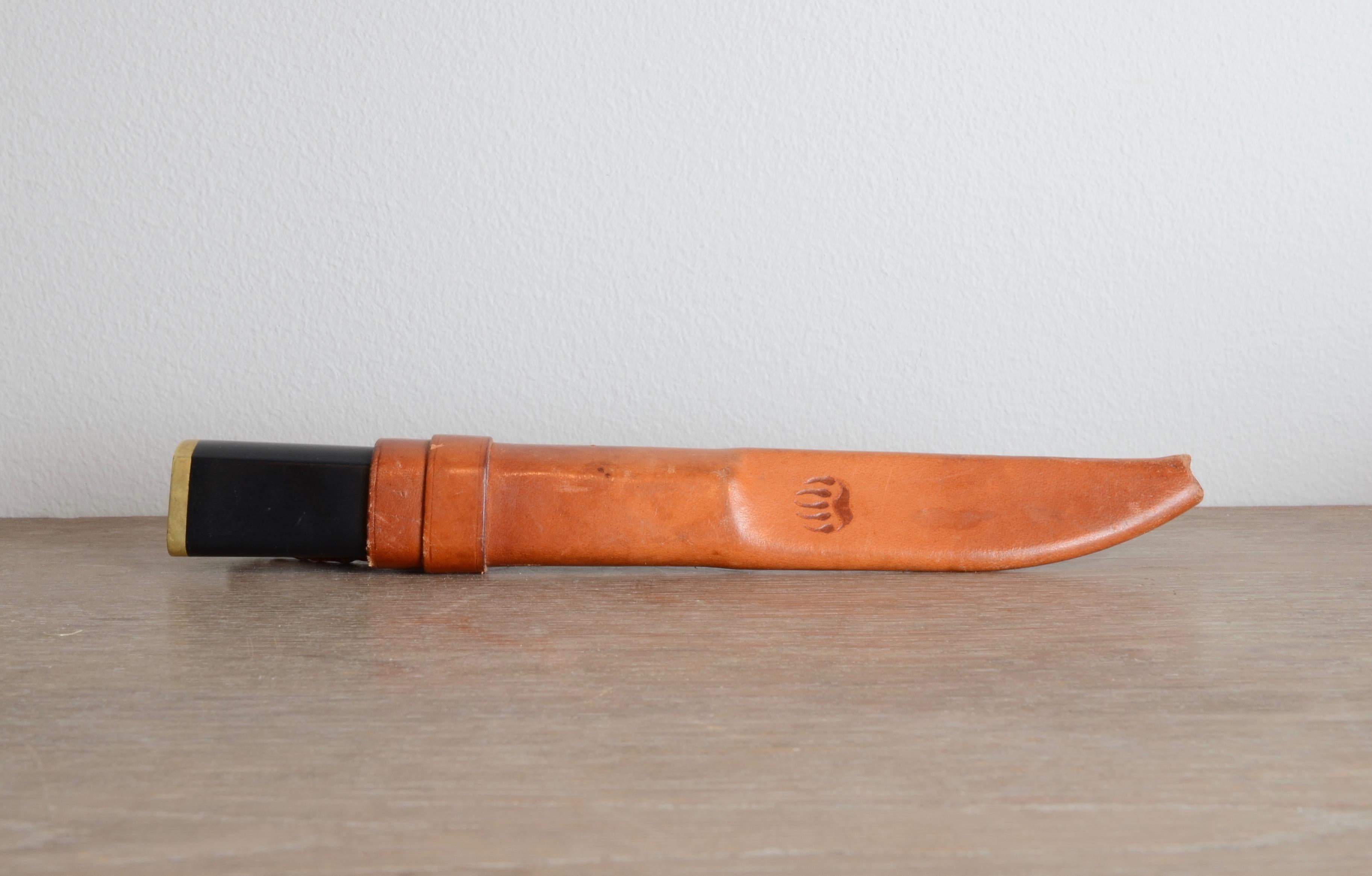 Knife with sheath model Puukko, designed by Tapio Wirkkala for Hackman & Co, Helsinki 1961. 

Steel blade, brass fittings, and leather sheath.