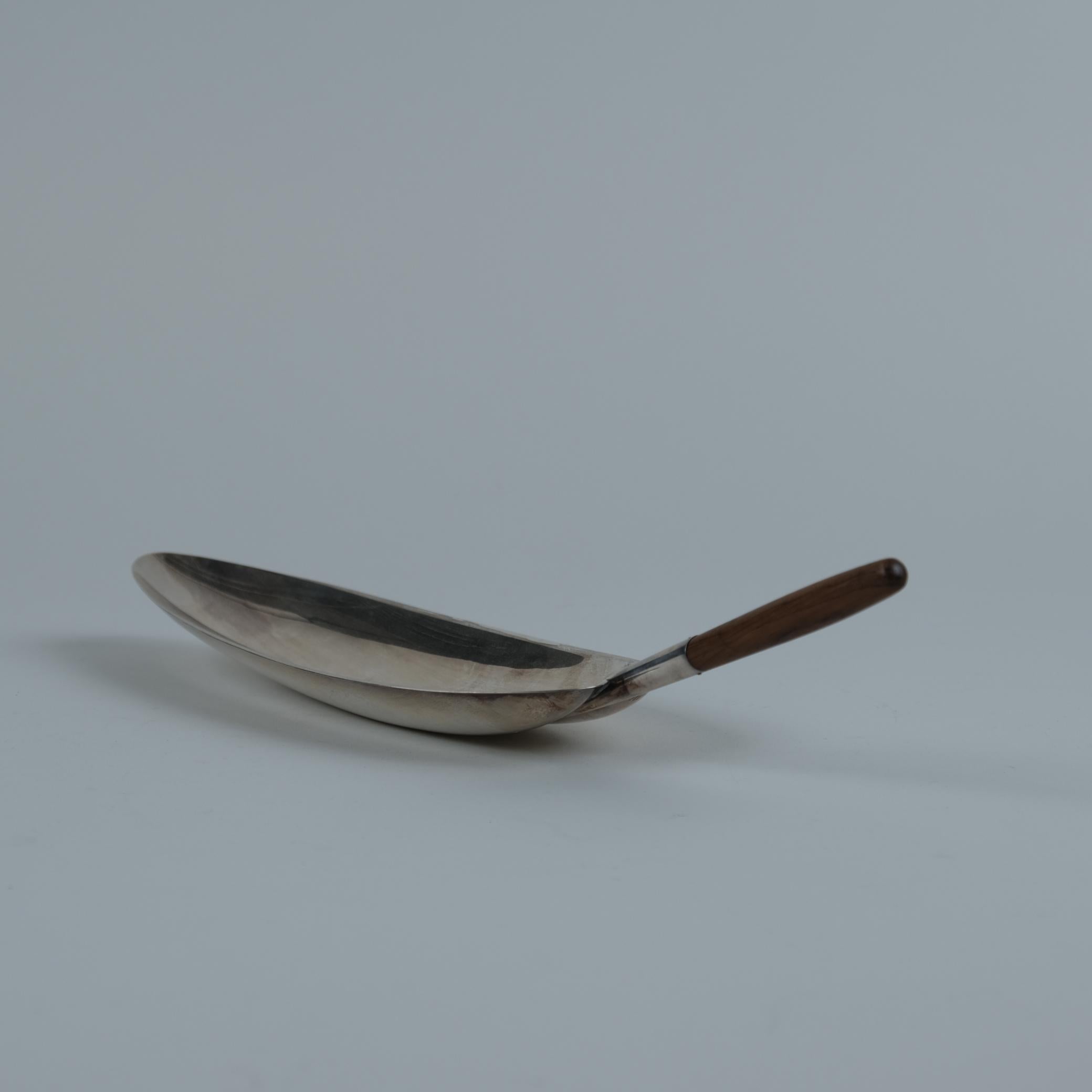 Un piatto da portata in argento a forma di foglia con manico in teak, modello TW85, progettato e firmato da Tapio Wirkkala. Questo piatto risale al 1956. Un perfetto esempio dei geniali disegni di Wirkkala derivati dalla natura.
Realizzato solo su