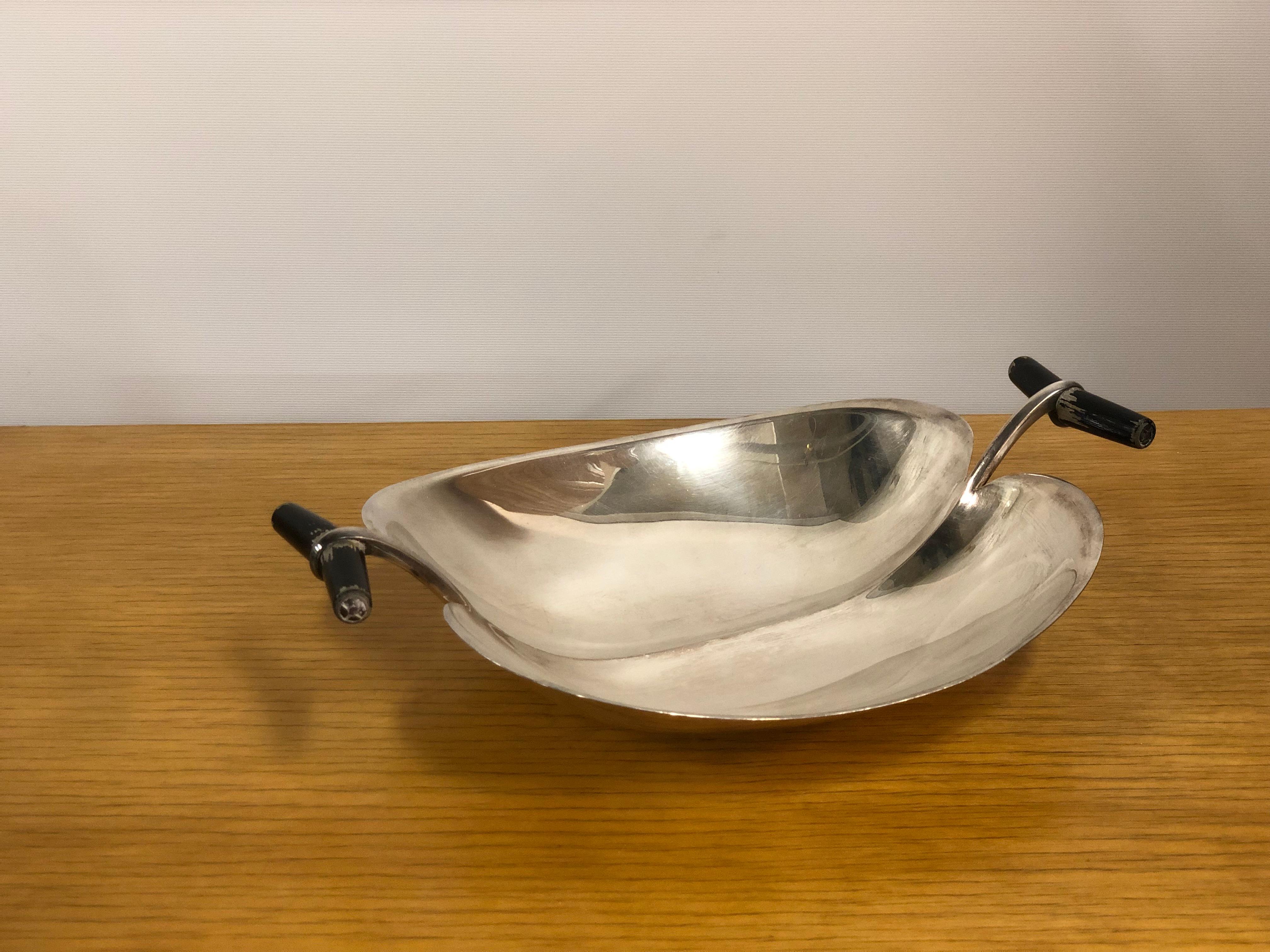 Tapio Wirkkala serving dish in silver with wooden handles, made in the 1950s. This piece displays one of Wirkkala's many beautiful designs almost resembling a seashell. The bottom of the dish is marked 